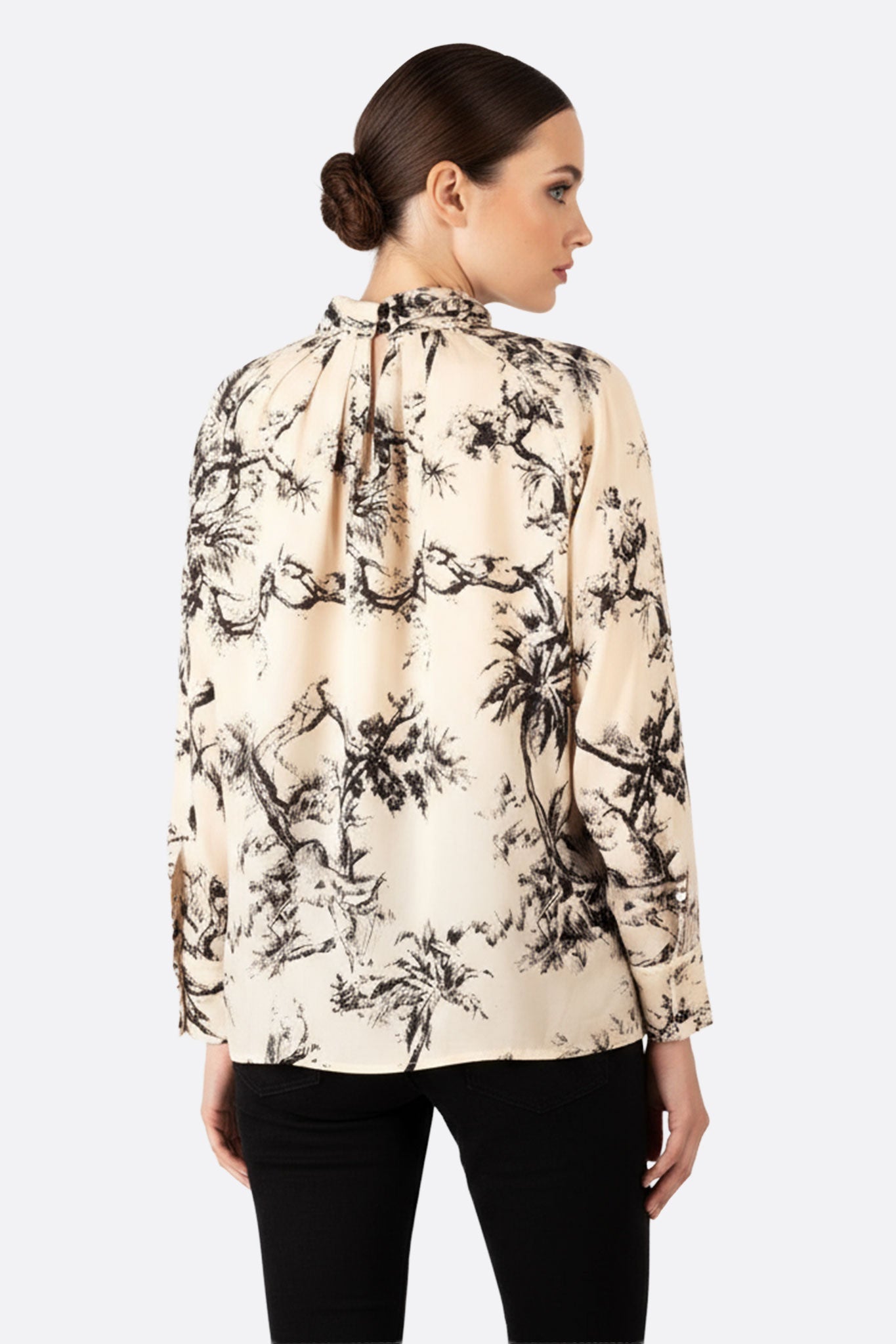 Détail raffiné de la blouse oversize en toile de Jouy noir et blanc, mettant en lumière son élégance et sa matière luxueuse.