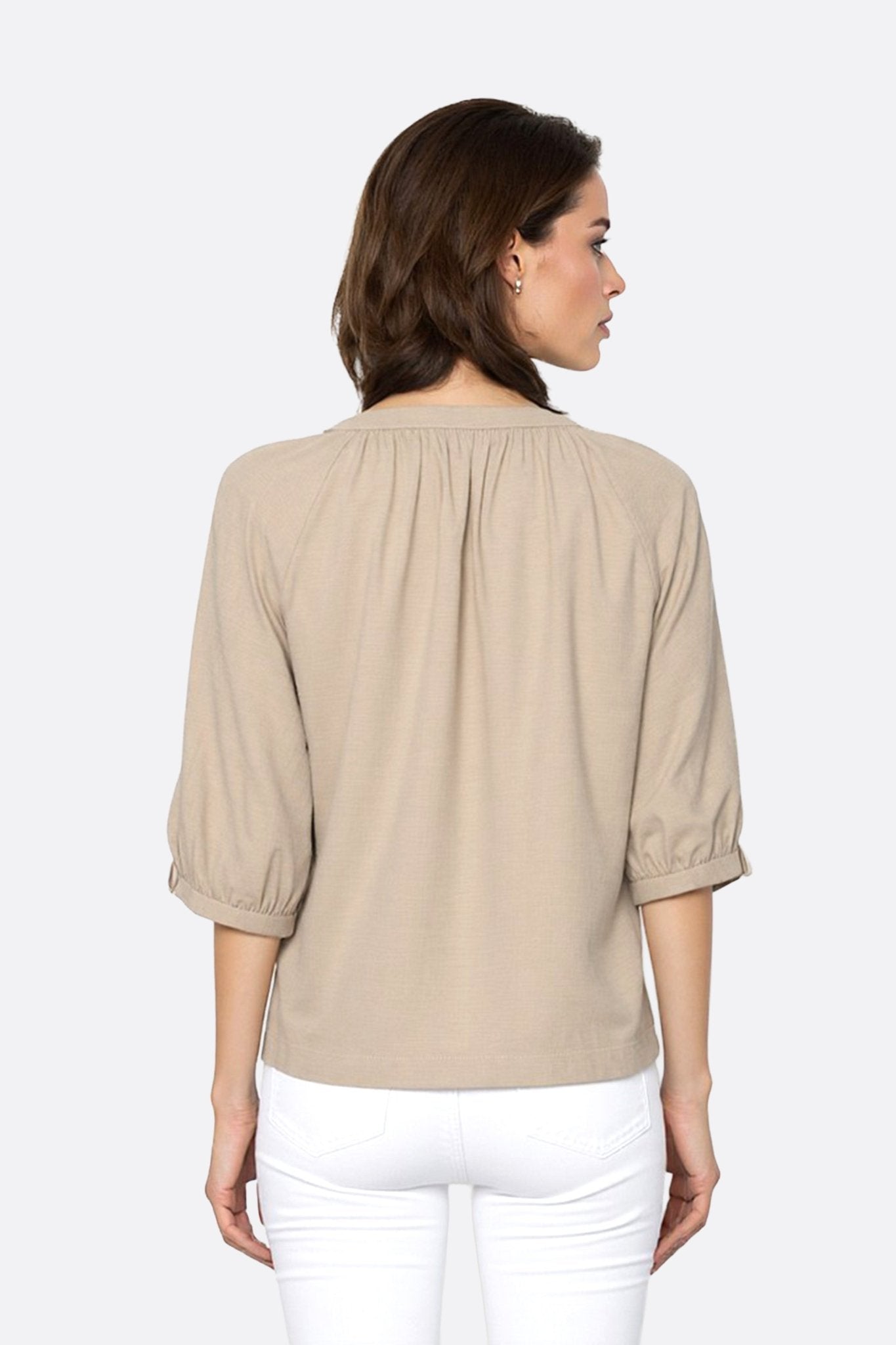 Détail au dos de la blouse beige en lin, mettant en avant la délicatesse des boutons et le tombé léger des manches...