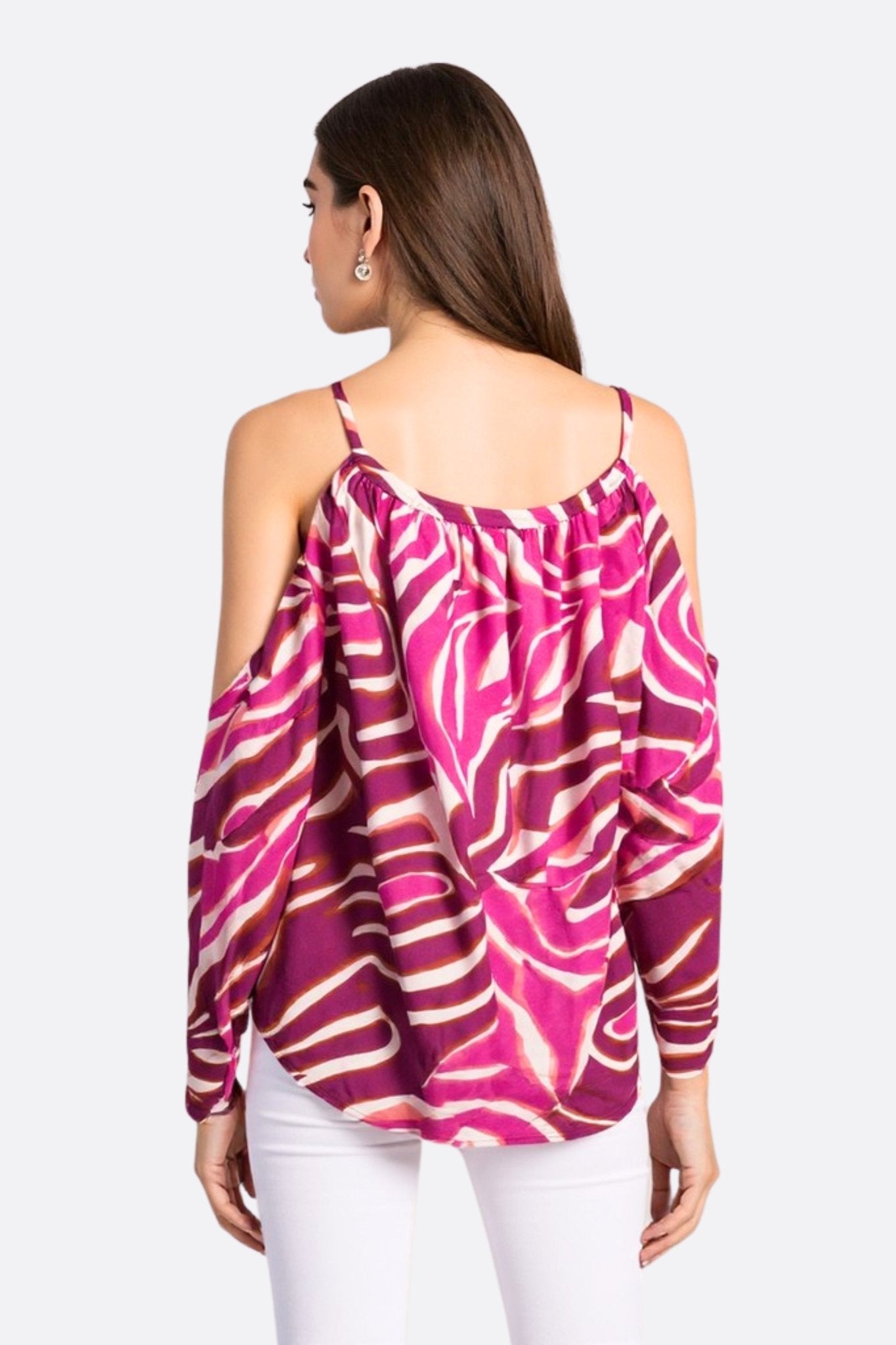 Détail rapproché de la blouse fluide fuchsia à motifs zébrés, révélant sa texture légère et son charme audacieux pour...