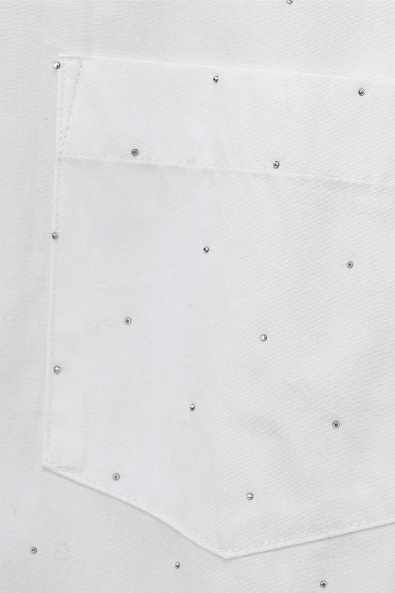 Zoom sur la chemise blanche ample à strass, une pièce chic et raffinée, idéale pour une allure moderne et sophistiquée.