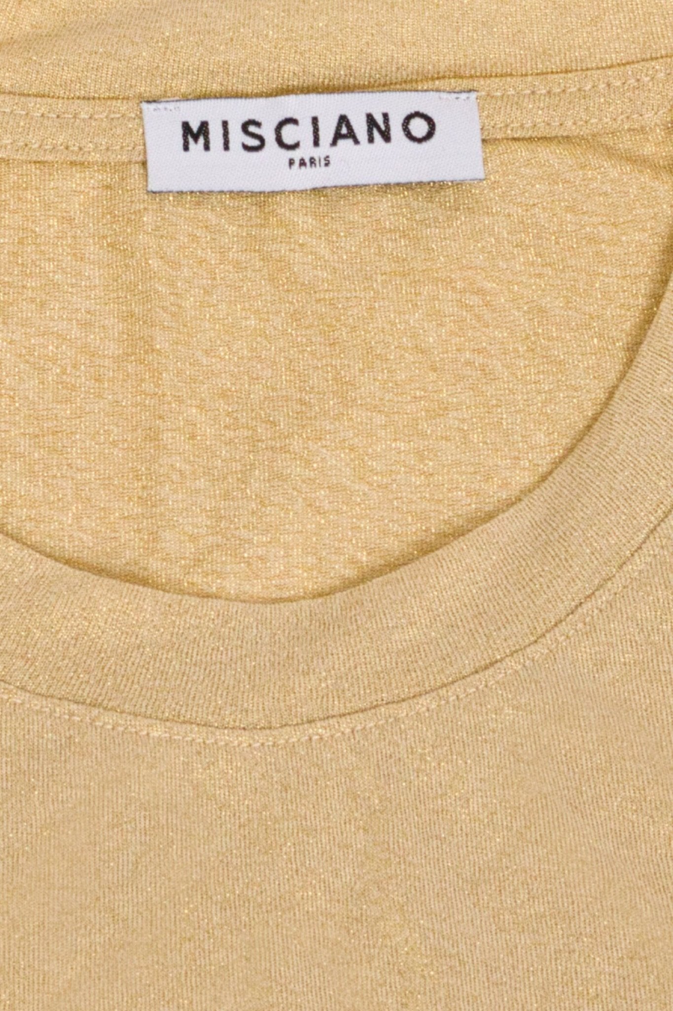 Détail raffiné du débardeur beige en tissu scintillant, soulignant sa texture fluide et son élégance discrète pour les...