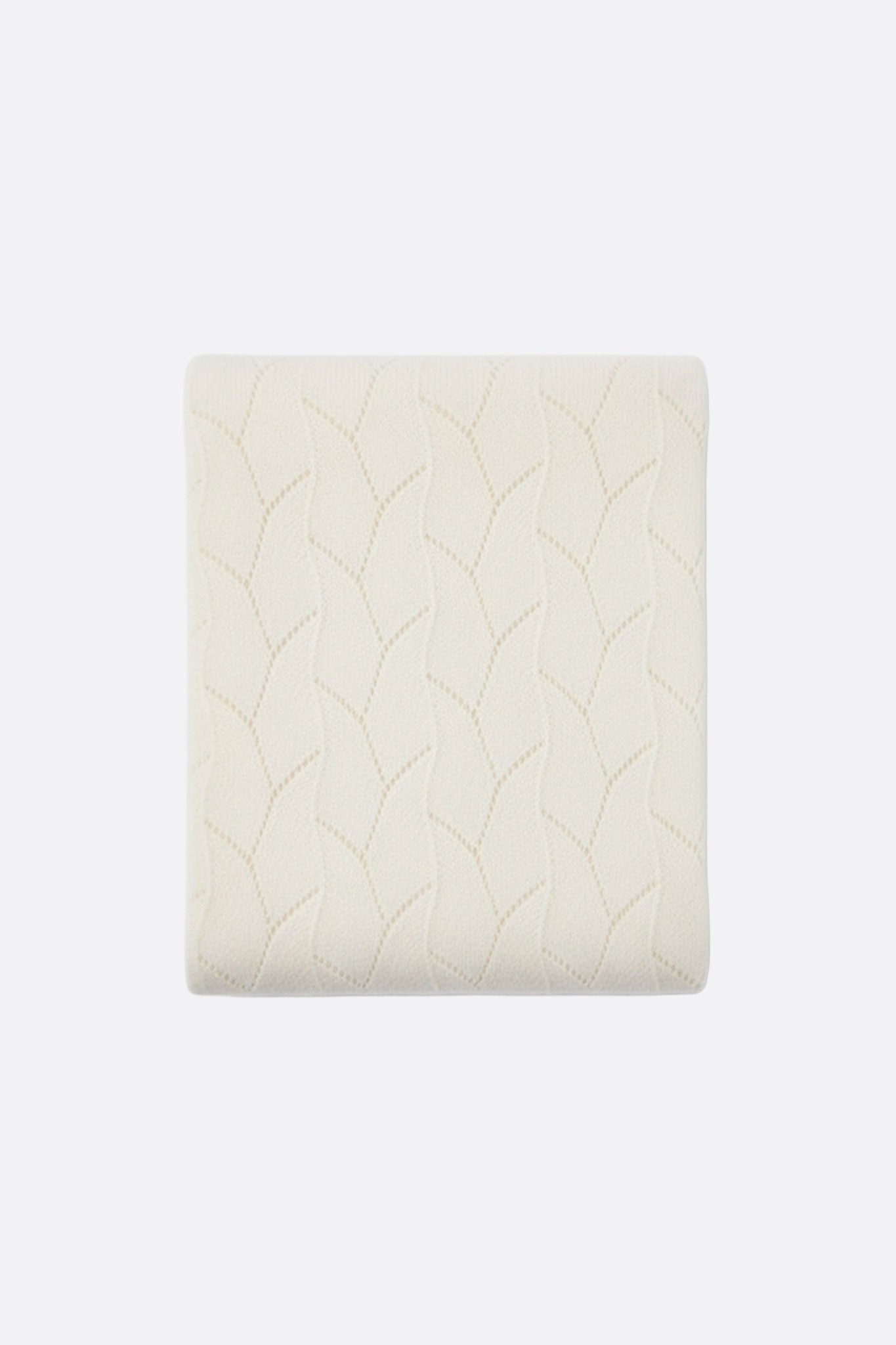 Détail de l'écharpe en cachemire blanc, mettant en lumière sa maille ajourée délicate, idéale pour un look intemporel et...