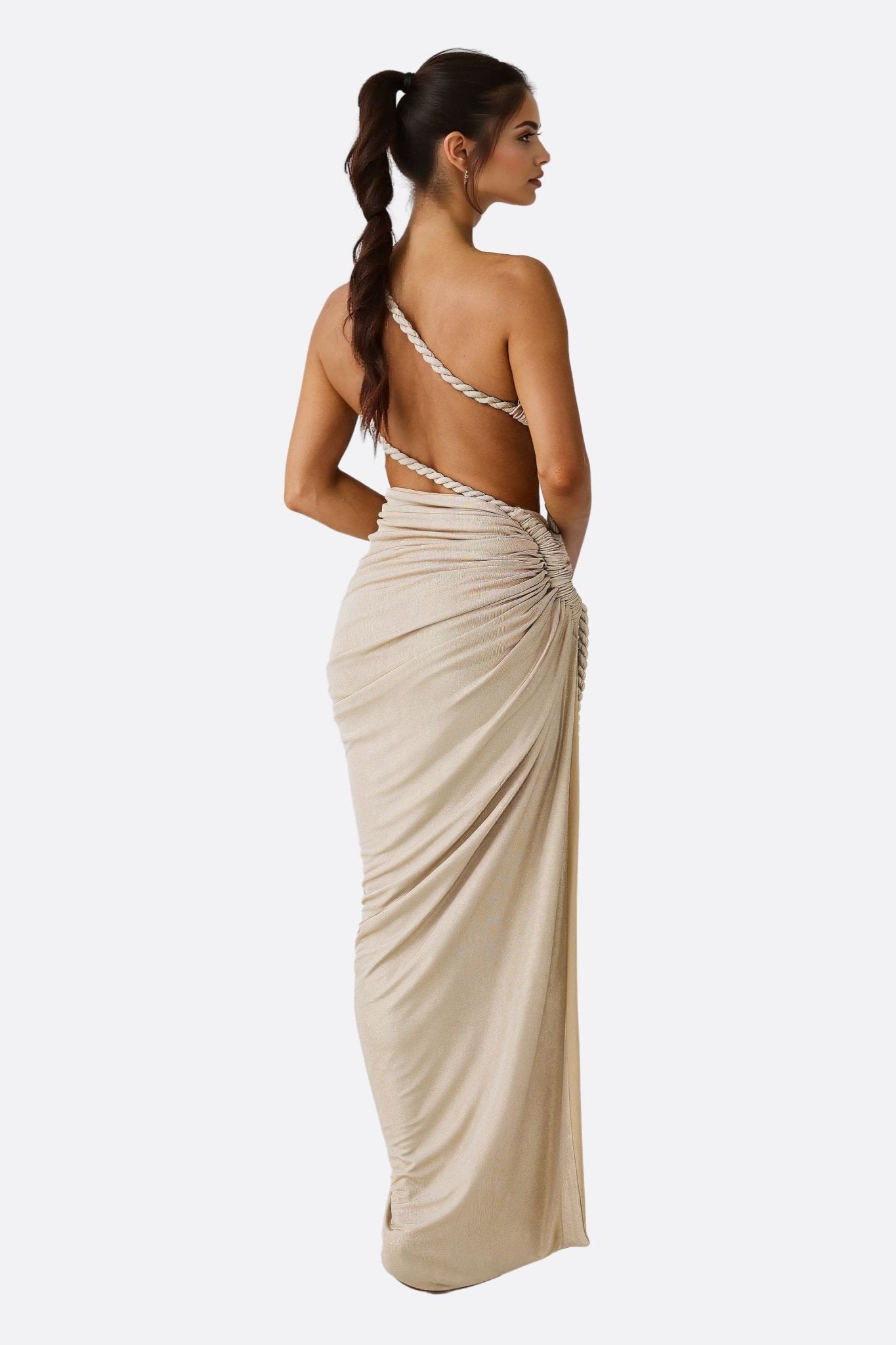 Texture satinée de l'ensemble drapé beige, soulignant son design asymétrique et moderne, idéal pour les soirées d'été.