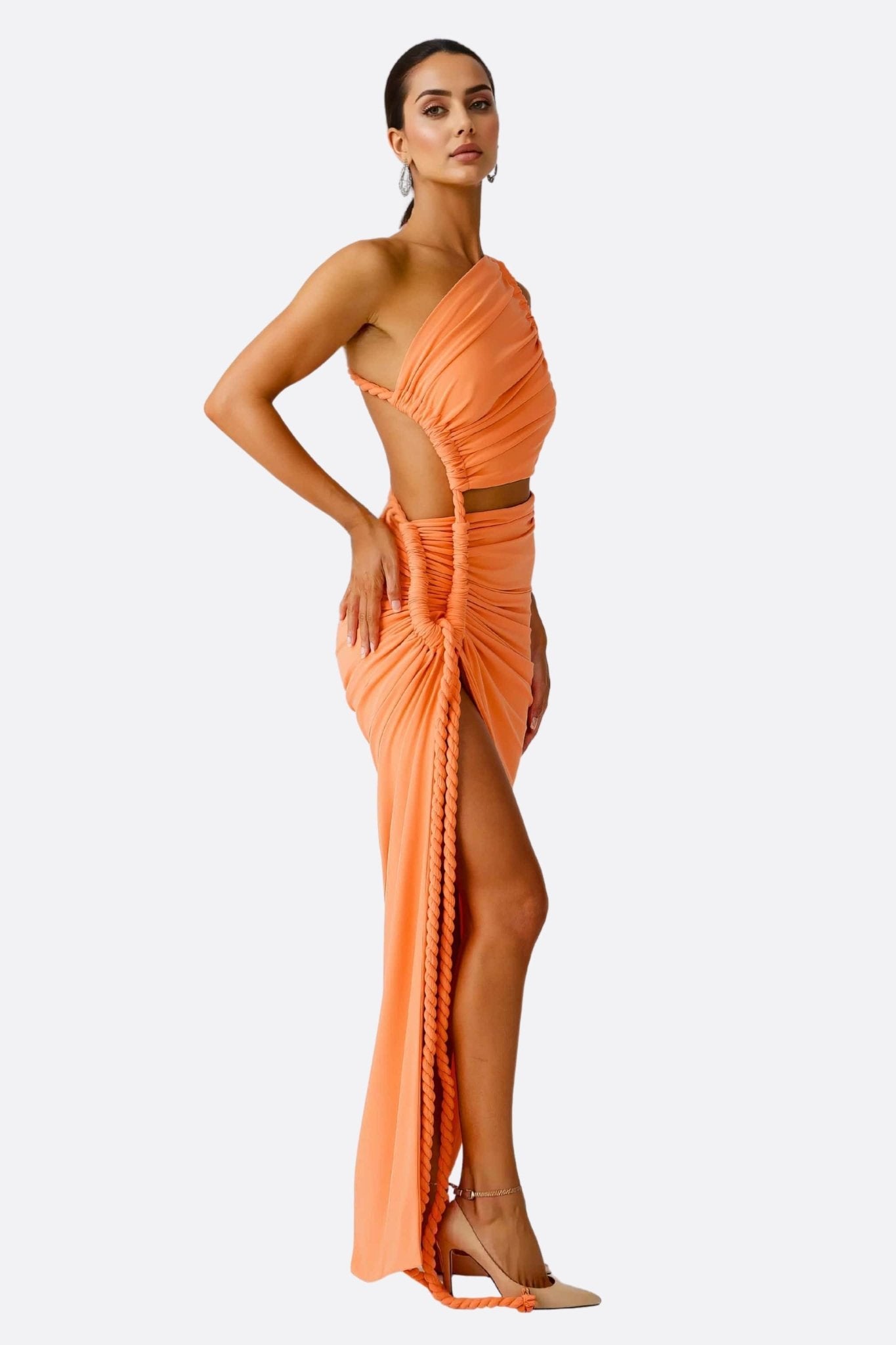 Détail du tissu drapé orange lumineux de cet ensemble beachwear sophistiqué, idéal pour des événements estivaux chics.