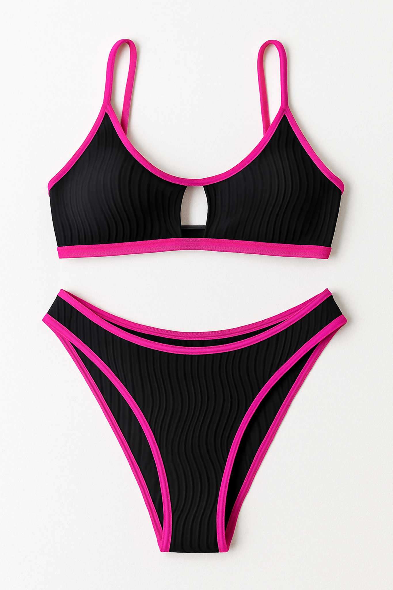Détail du bikini noir à liseré rose, révélant la texture du tissu chic et les bretelles fines pour un look raffiné.