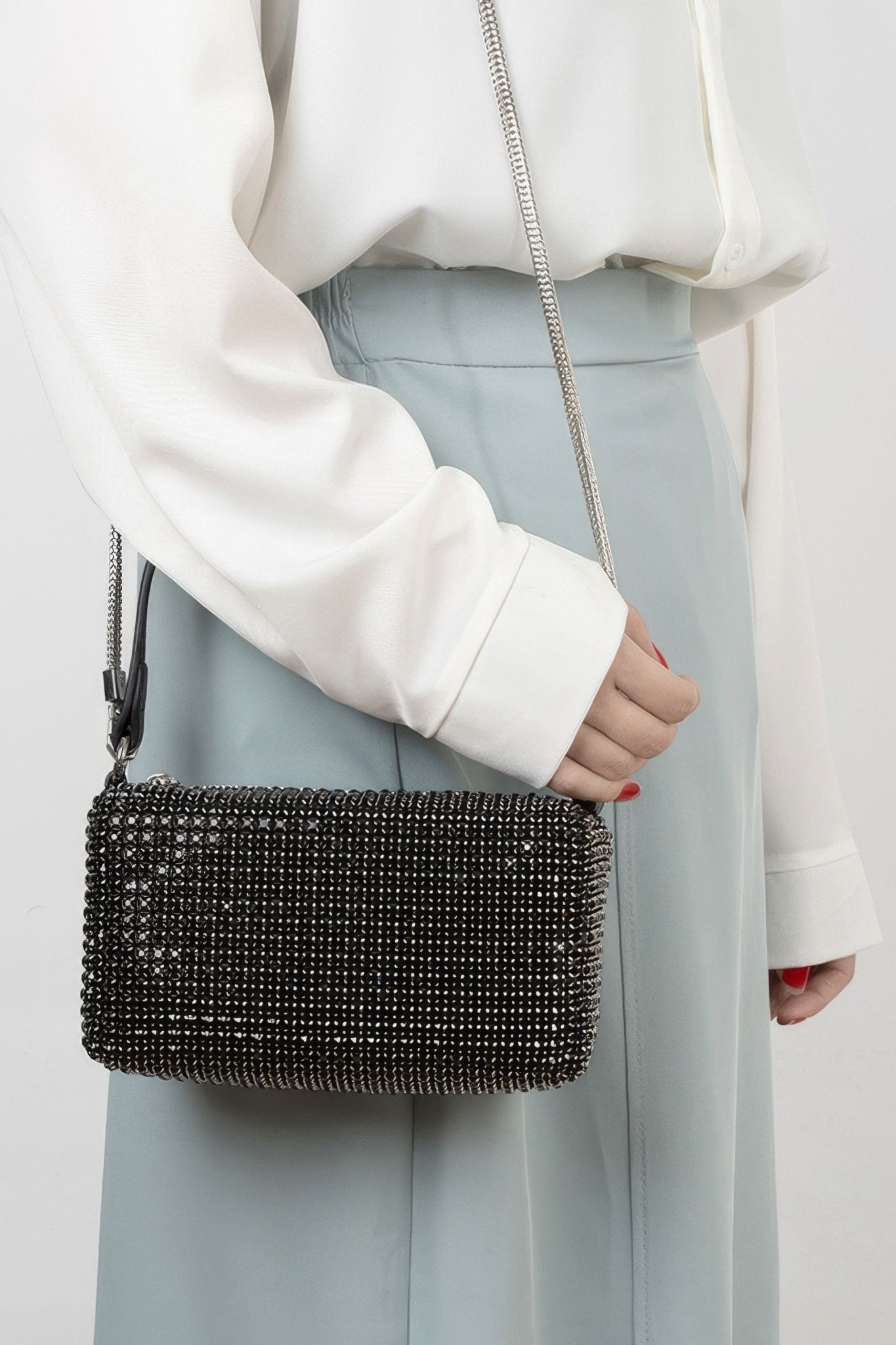 Détail du mini sac à strass noirs, élégant revêtement et anse raffinée, accessoire parfait pour des événements chics.