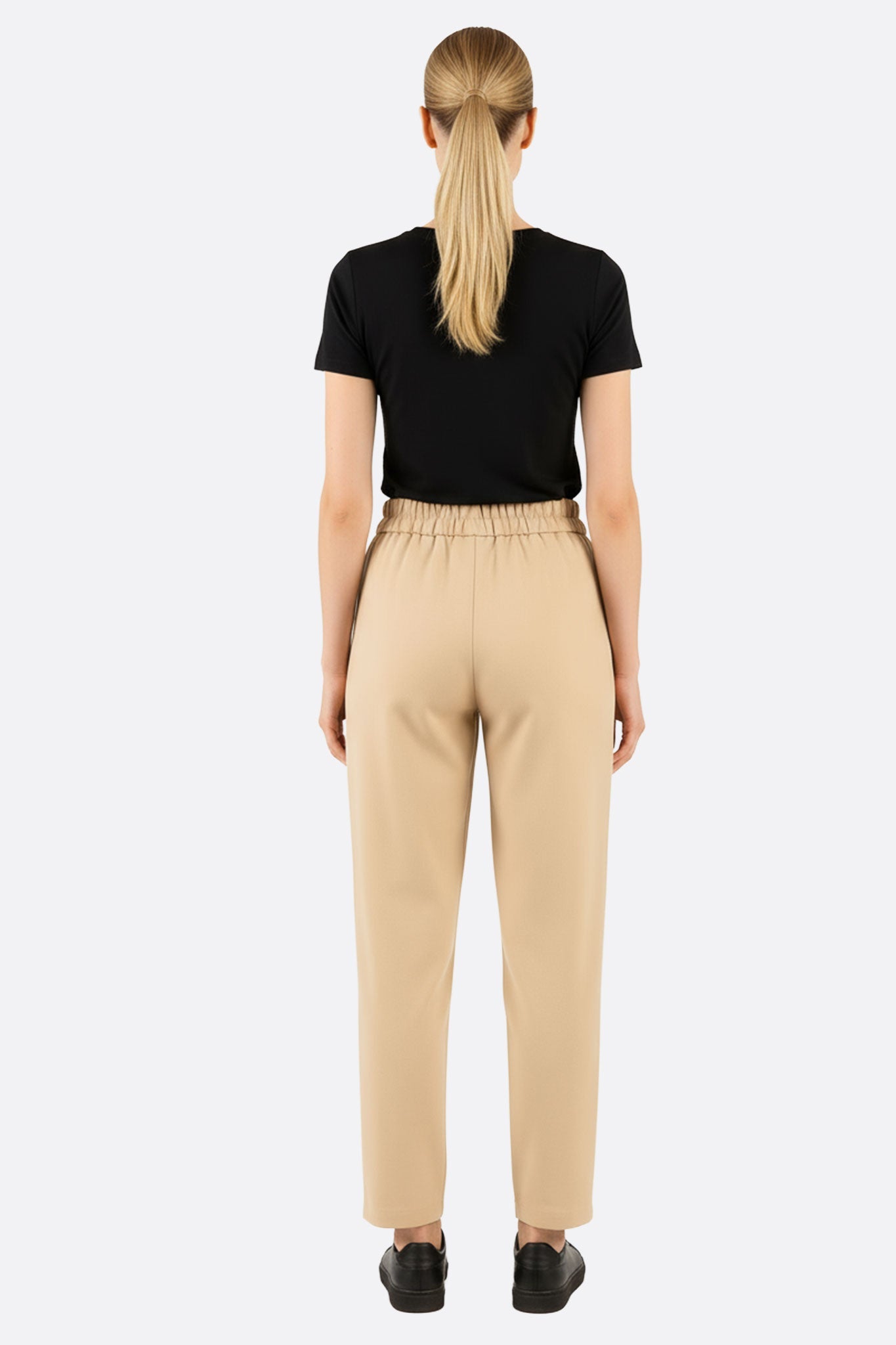 Détail du dos du pantalon beige à taille élastique, combinant confort et raffinement pour un look moderne.