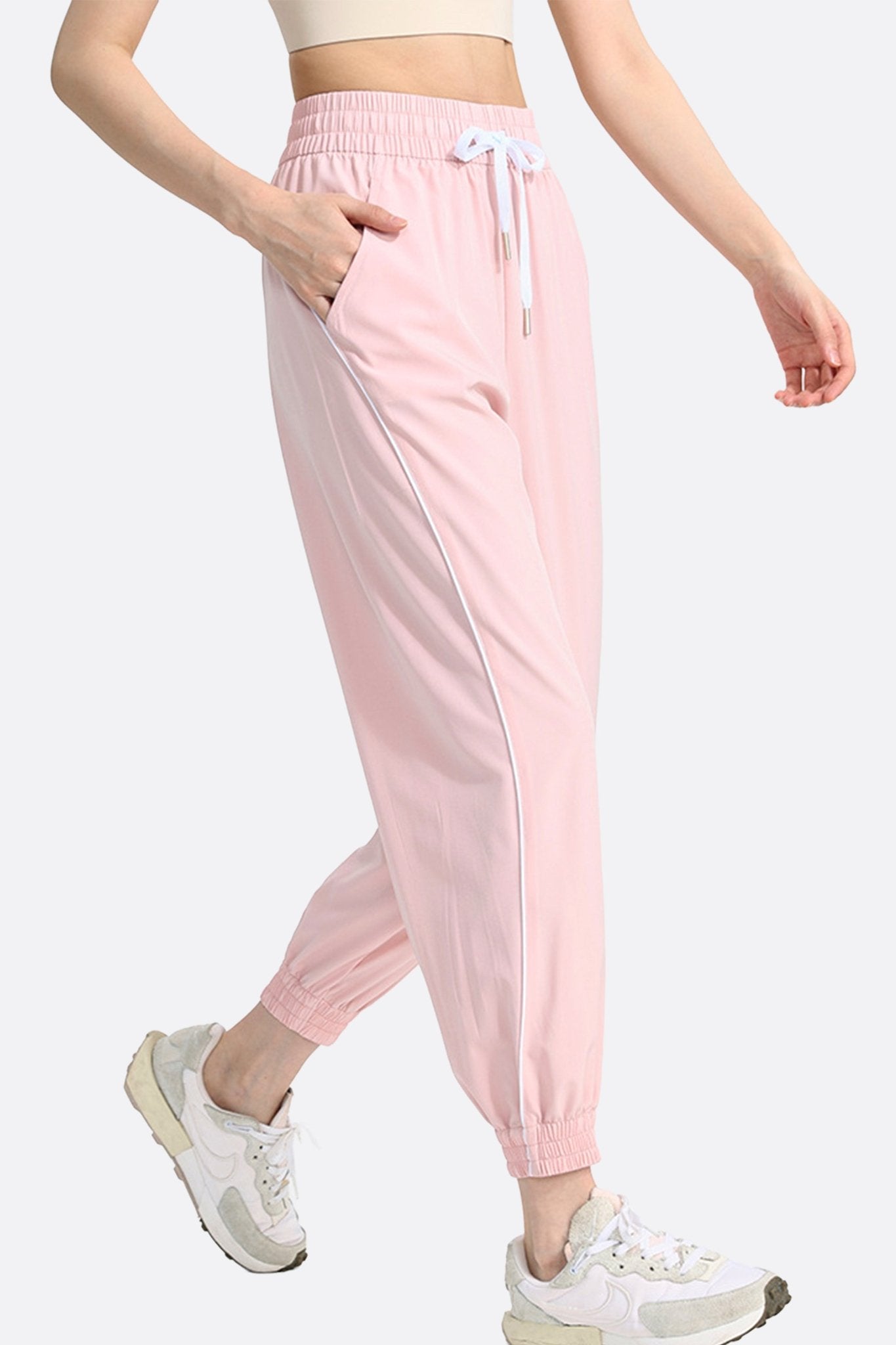 Zoom sur le dos du pantalon de jogging rose, mettant en avant sa texture légère et son design raffiné pour un look...