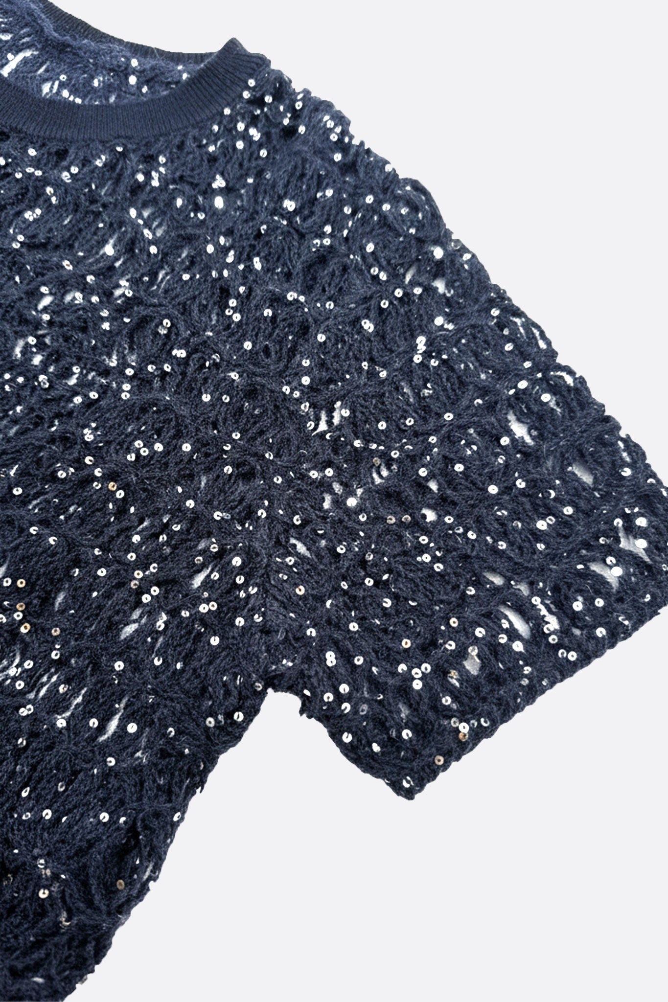 Détail du pull bleu marine en maille ajourée, mettant en lumière la texture moelleuse en mohair et lurex pour un style chic.