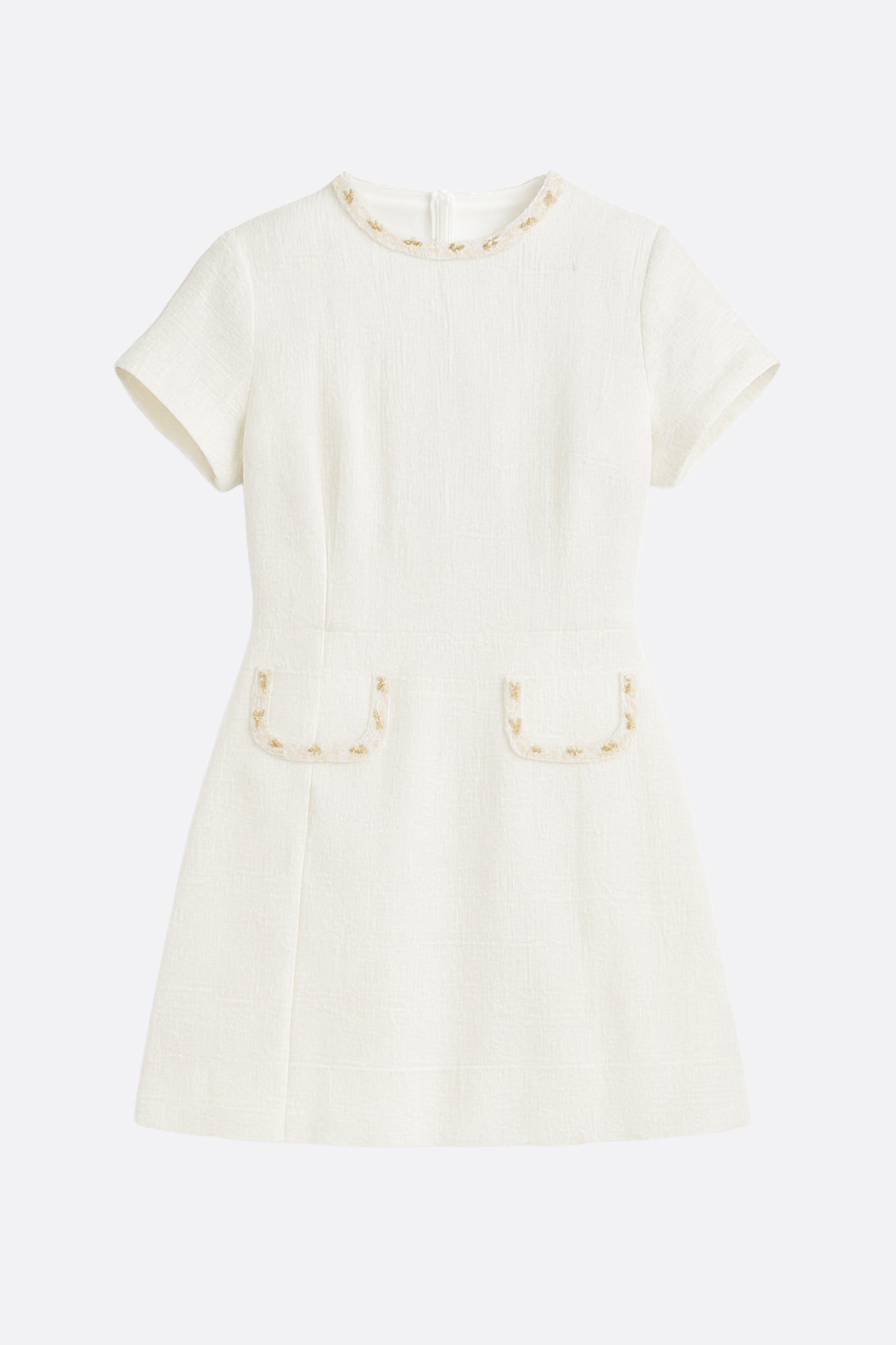 Fermeture et texture détaillées de la robe courte en tweed ivoire ornée d'un col perlé doré pour un style distingué.