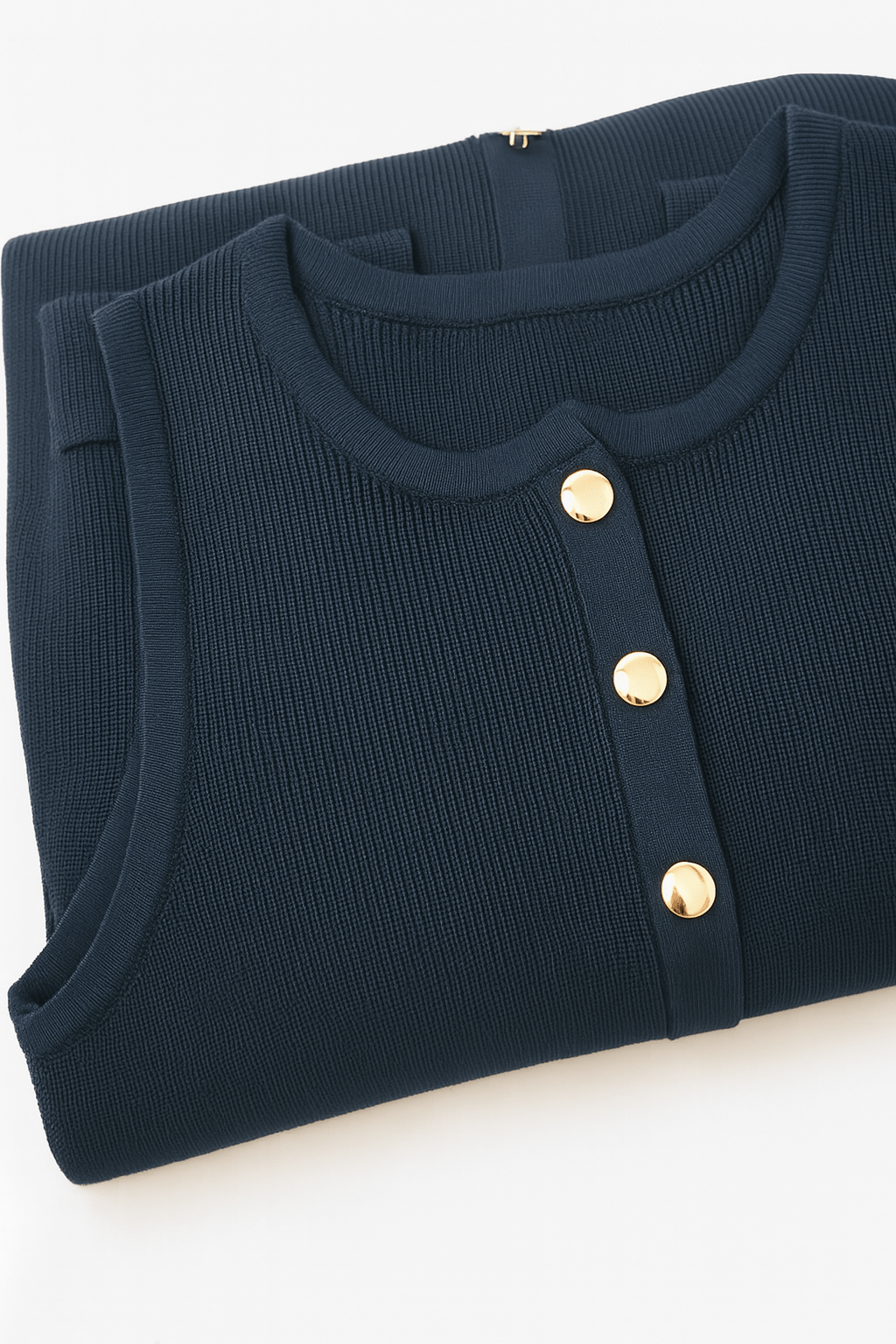 Robe en maille côtelée bleu marine sans manches, zoom sur la texture élégante et les boutons raffinés, parfaite pour le...