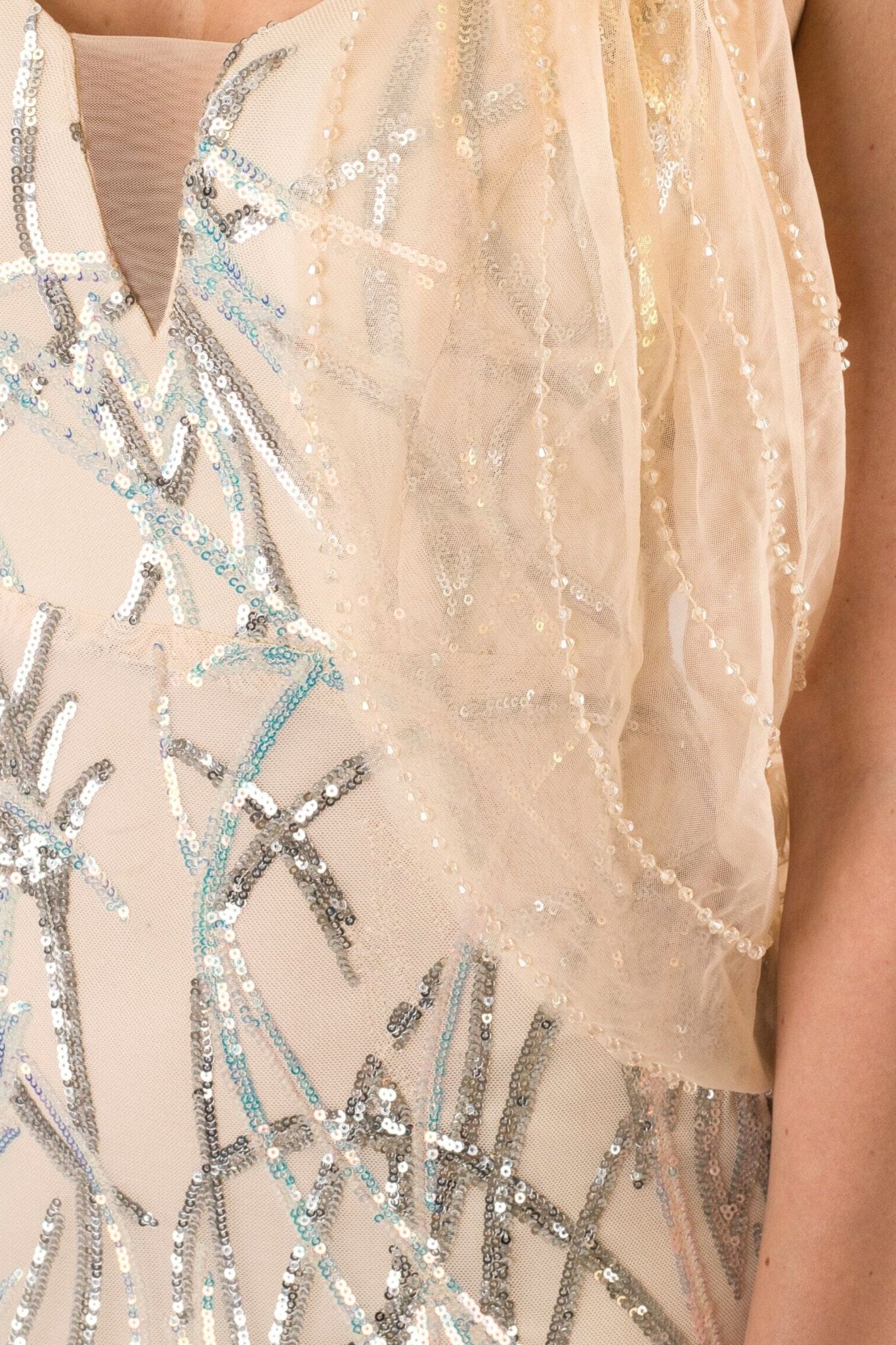 Détail du dos de la robe longue nude parsemée de sequins argentés, drapé aérien pour un look chic et moderne.
