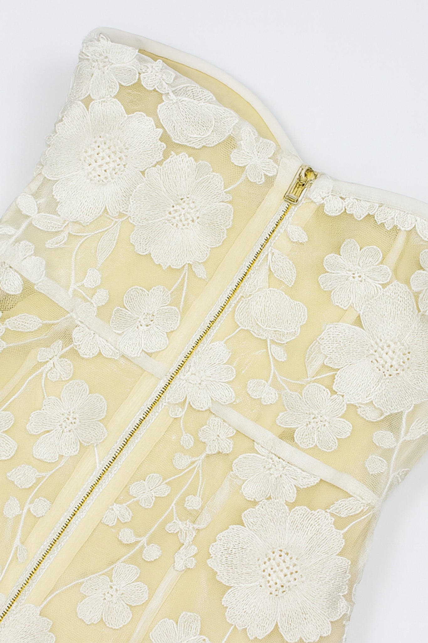 Zoom sur le dos de la robe midi bustier en tulle transparent, mettant en avant la dentelle florale pour un style chic.