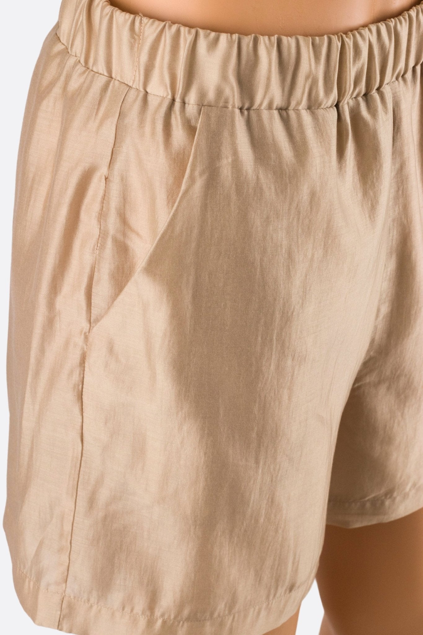 Vue rapprochée du short beige léger à taille élastique, idéal pour une allure élégante lors des journées ensoleillées.