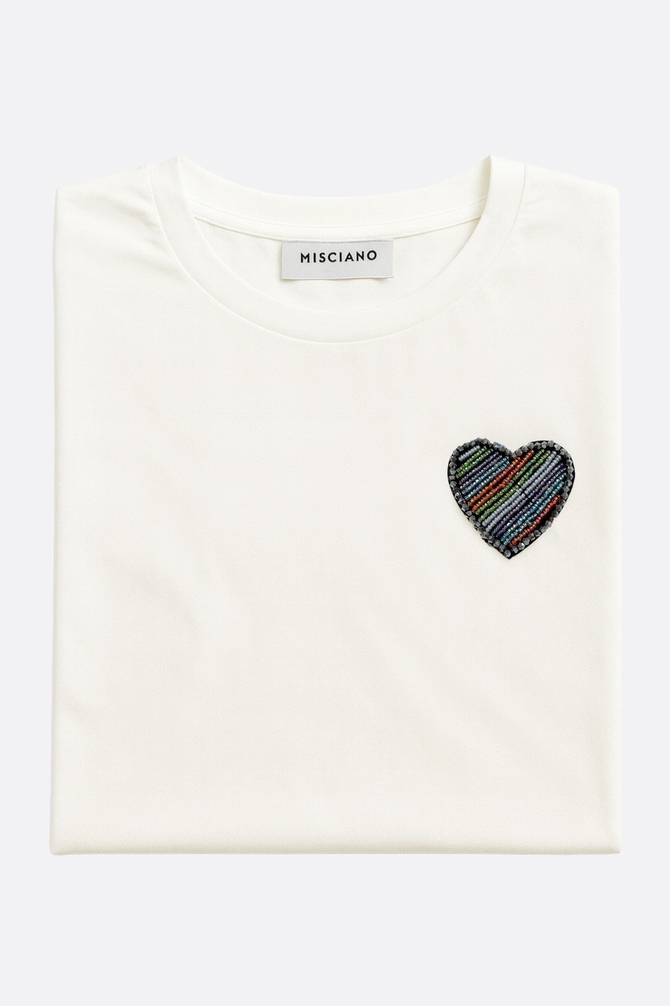 Détail délicat sur le dos d'un T-shirt blanc à manches courtes, broderie cœur, accessoire essentiel pour un look chic.