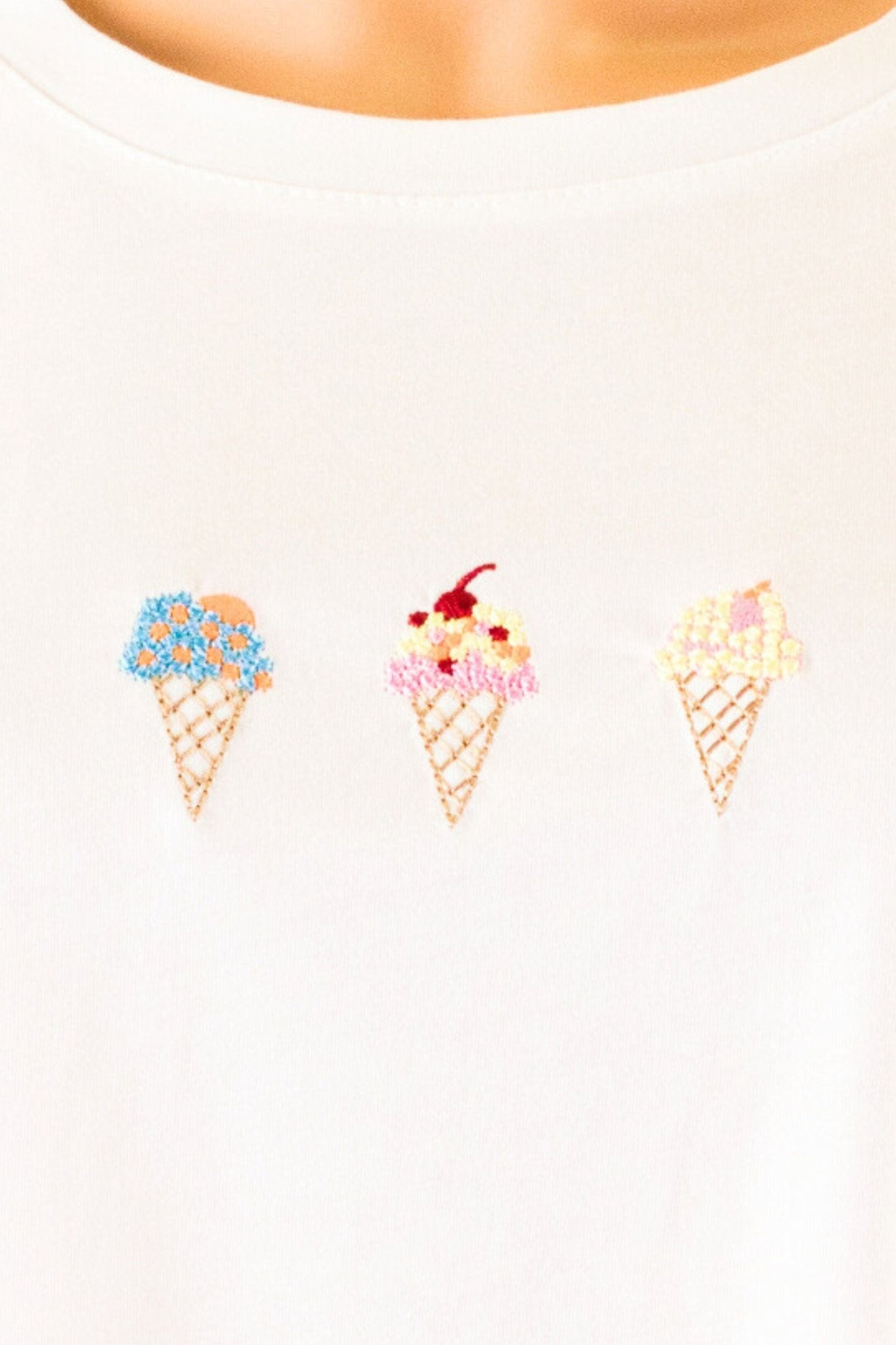 Détail de la texture douce et de la broderie délicate du t-shirt blanc oversize Gelato, parfait pour un style quotidien...