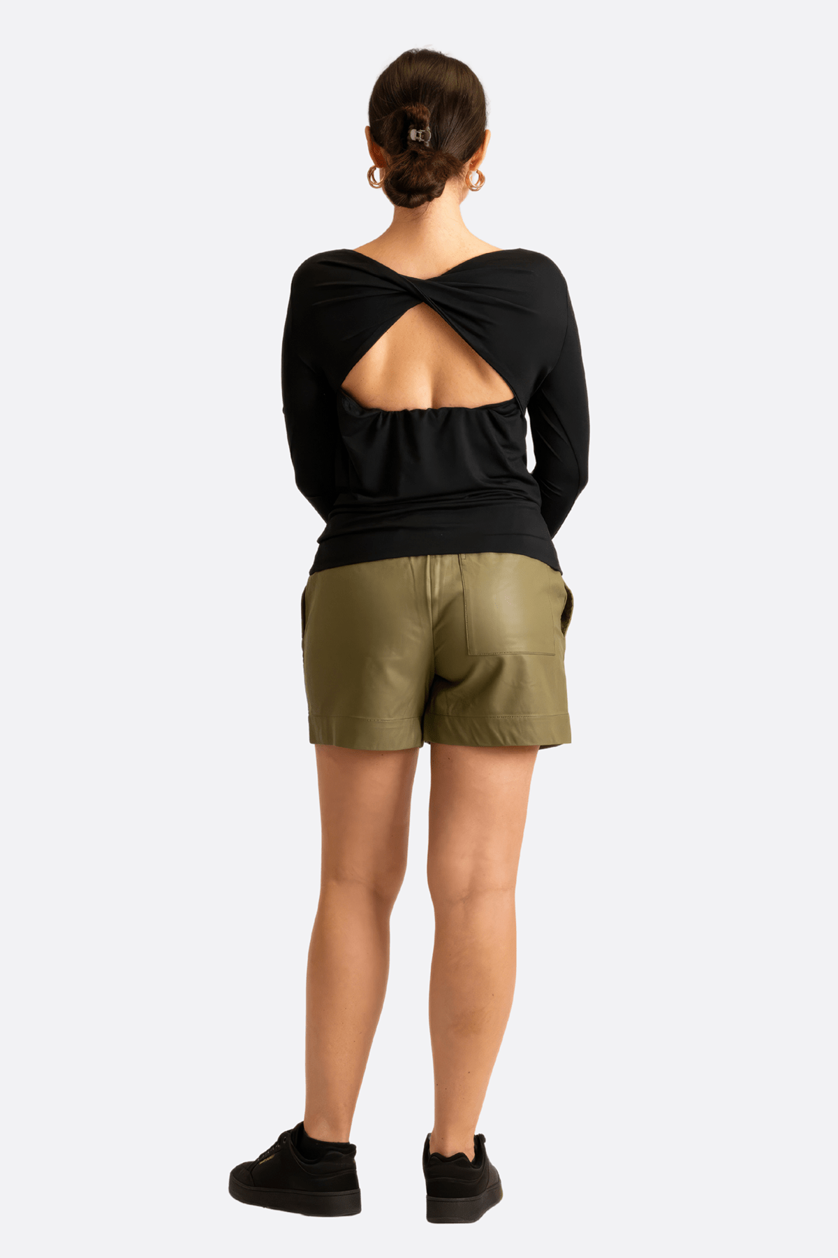 Détail sur la texture douce et extensible d'un t-shirt noir à manches longues, col bateau, pour une allure moderne et...