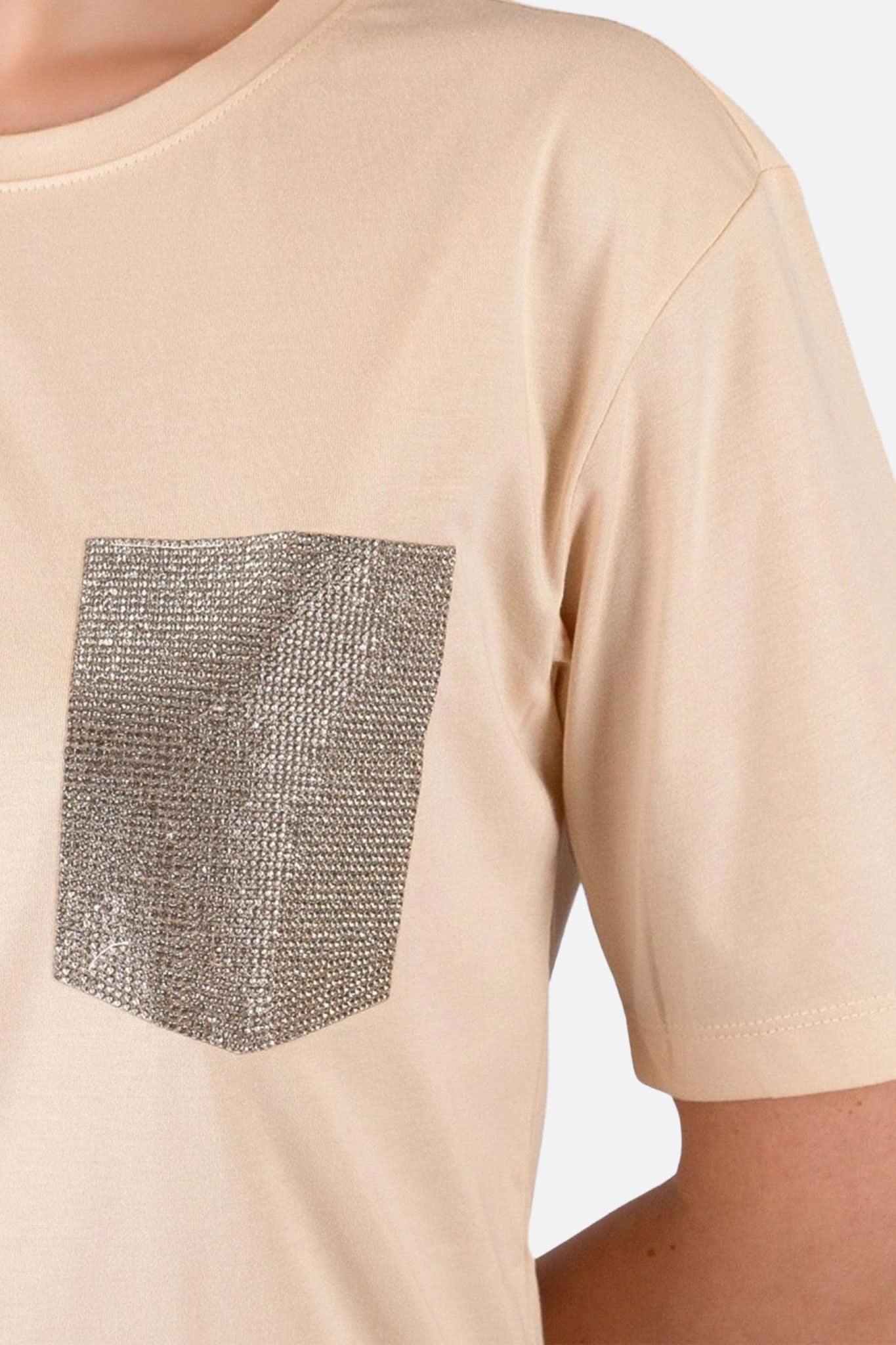 Détail scintillant d'un t-shirt rose pastel, une pièce raffinée idéale pour un look chic et décontracté.