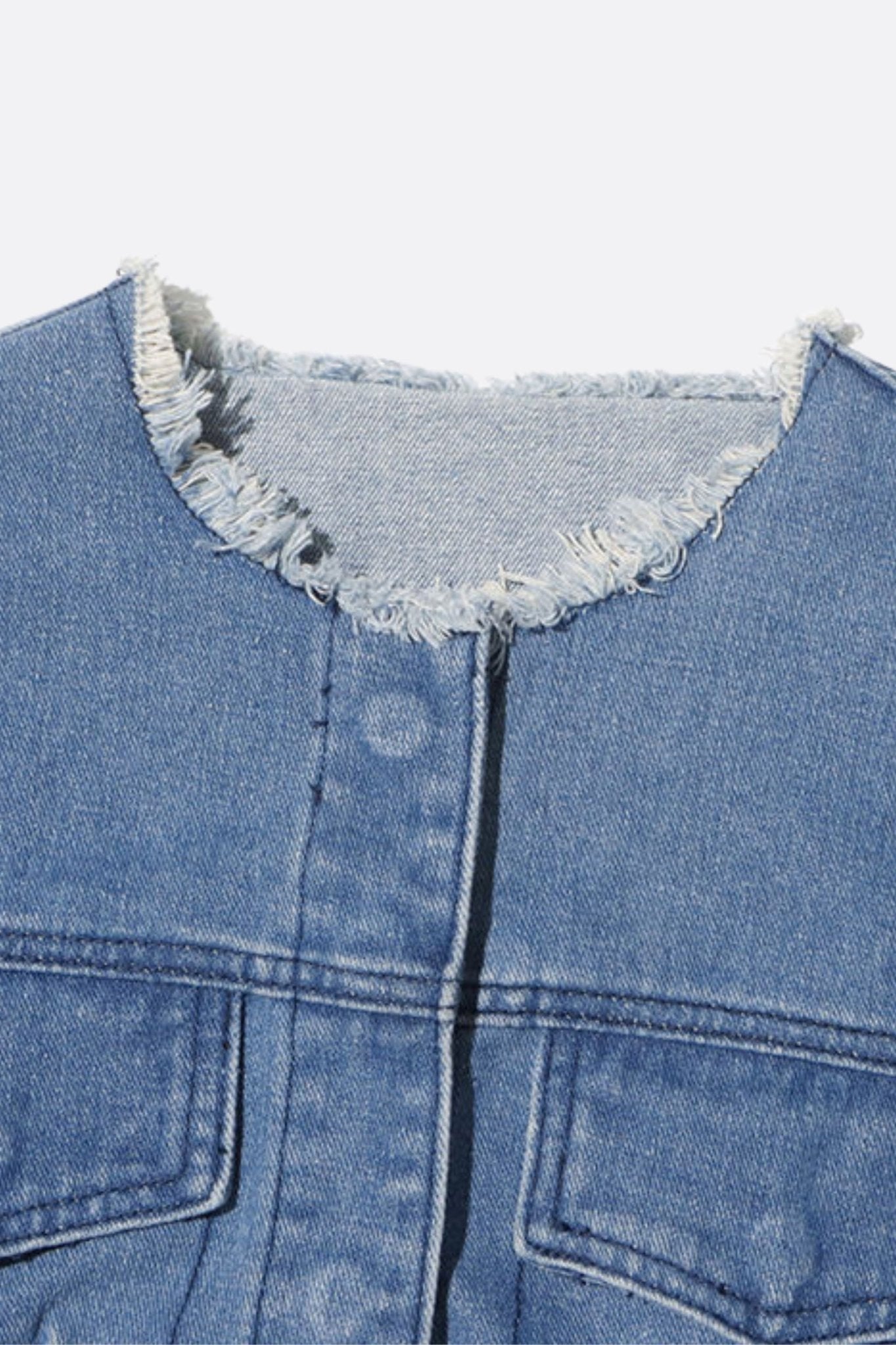 Détails raffinés de la veste en denim courte avec franges, ajoutant une touche moderne et élégante à vos tenues.