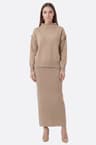 Long skirt and beige knit sweater with decorative details