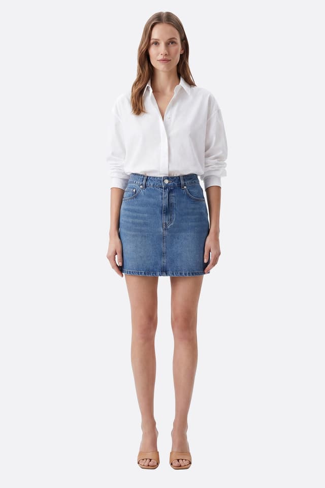 Modella frontale con gonna corta in denim di cotone dal taglio dritto, vita alta e tasche visibili