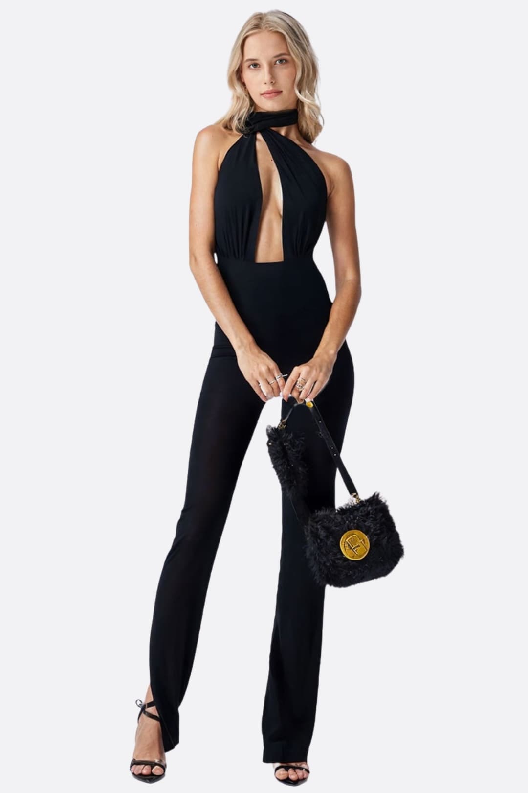 Combinaison noire chic à col noué, présentant une découpe frontale pour un look moderne idéal pour des soirées raffinées.