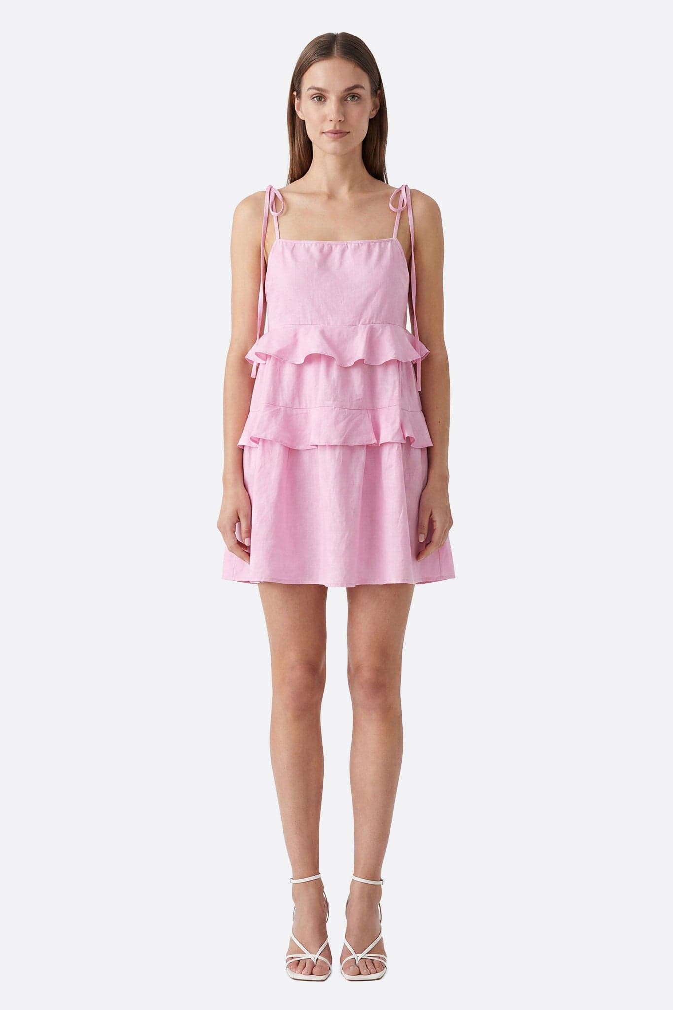 Model von vorn in einem kurzen rosa Rüschenkleid mit gebundenen Trägern