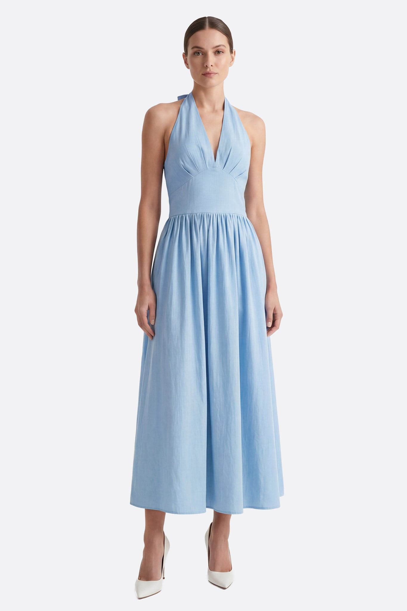 Model von vorne in einem pastellblauen Baumwoll-Midikleid mit offenem Rücken und taillierter Taille