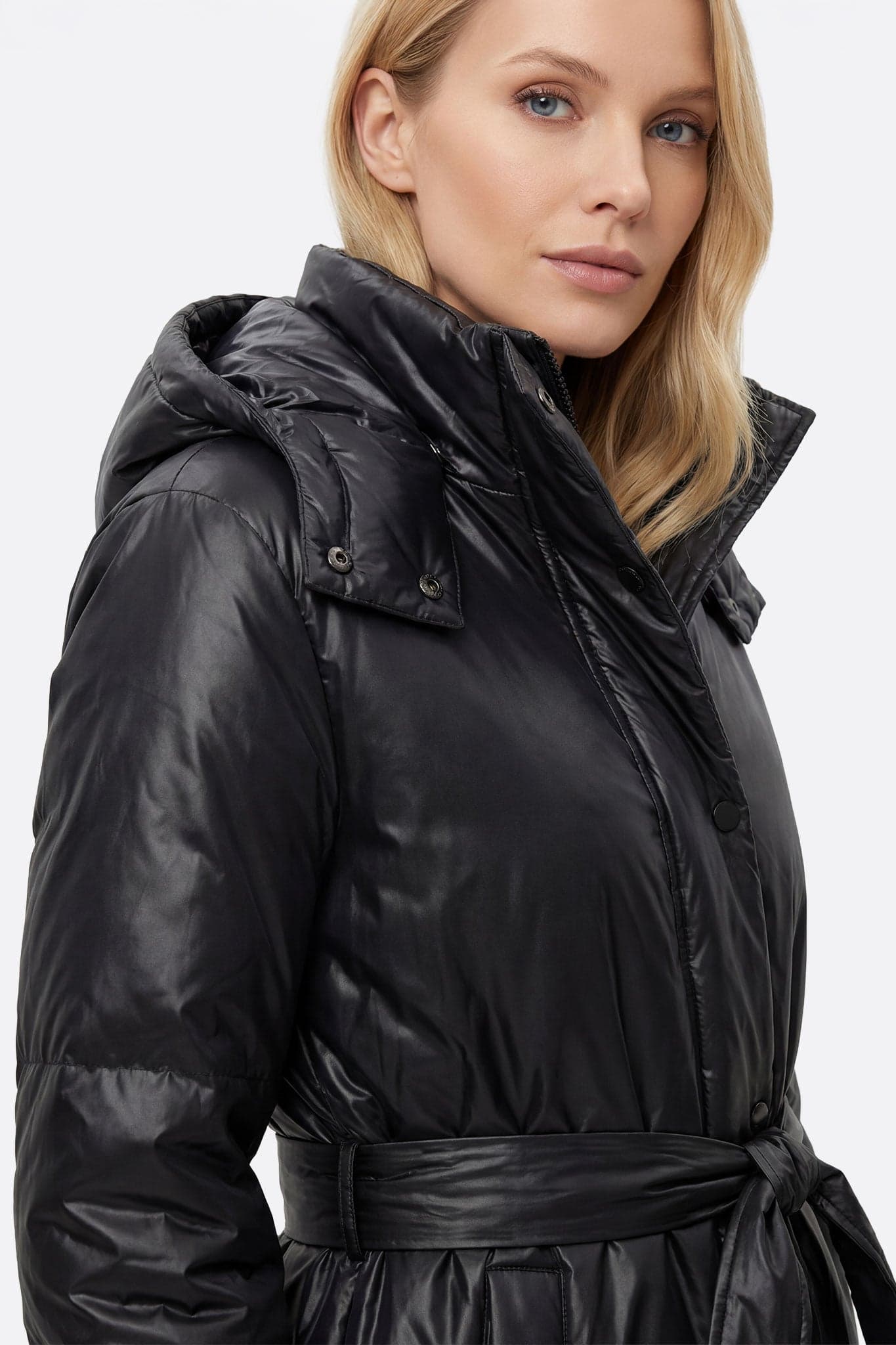 Schwarze Daunenjacke mit Gürtel aus gestepptem Material, ideal für einen schicken und warmen Look in der kalten Jahreszeit.