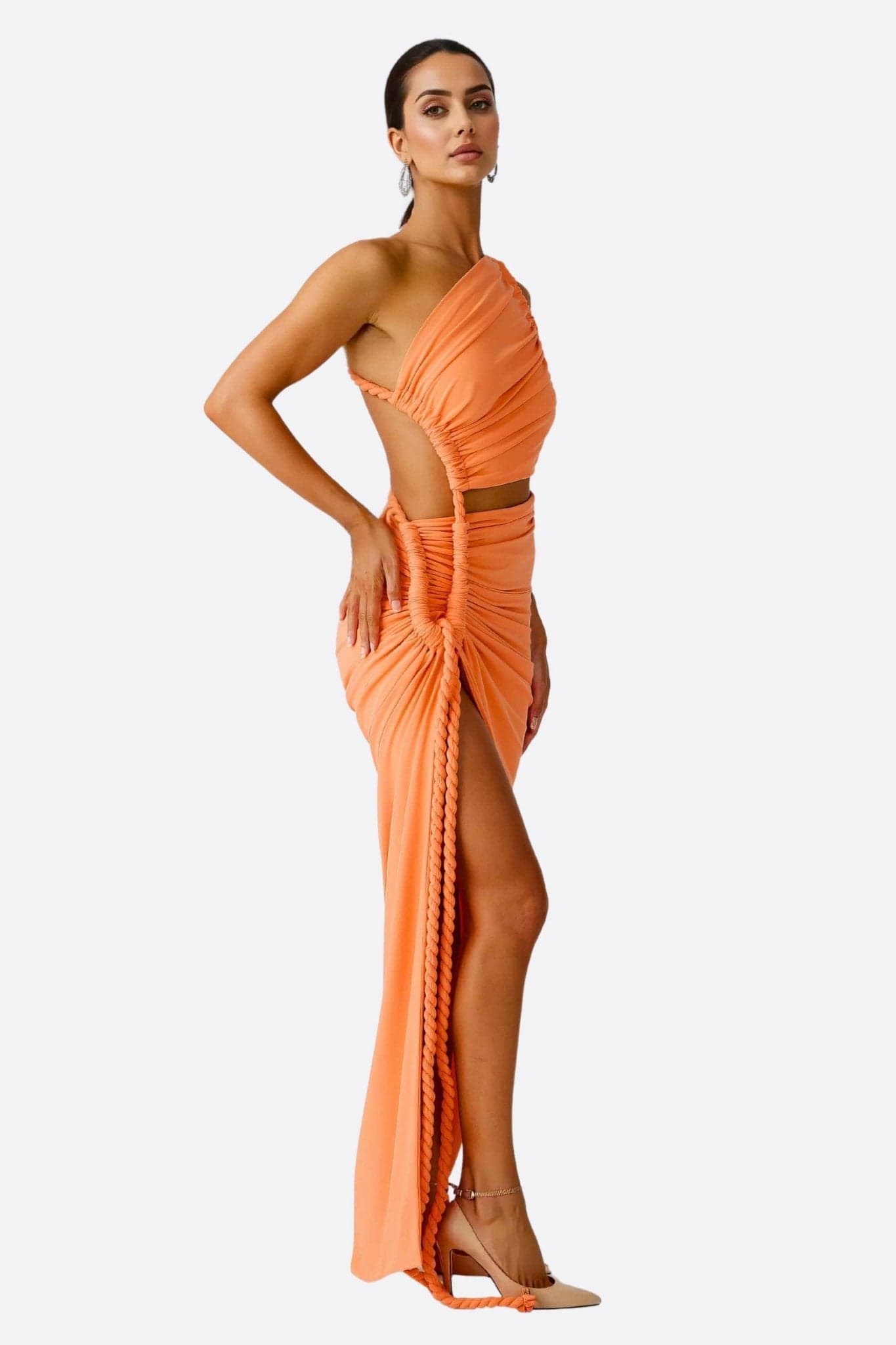 Detail of the bright orange draped fabric of this sophisticated beachwear set, ideal for chic summer events.