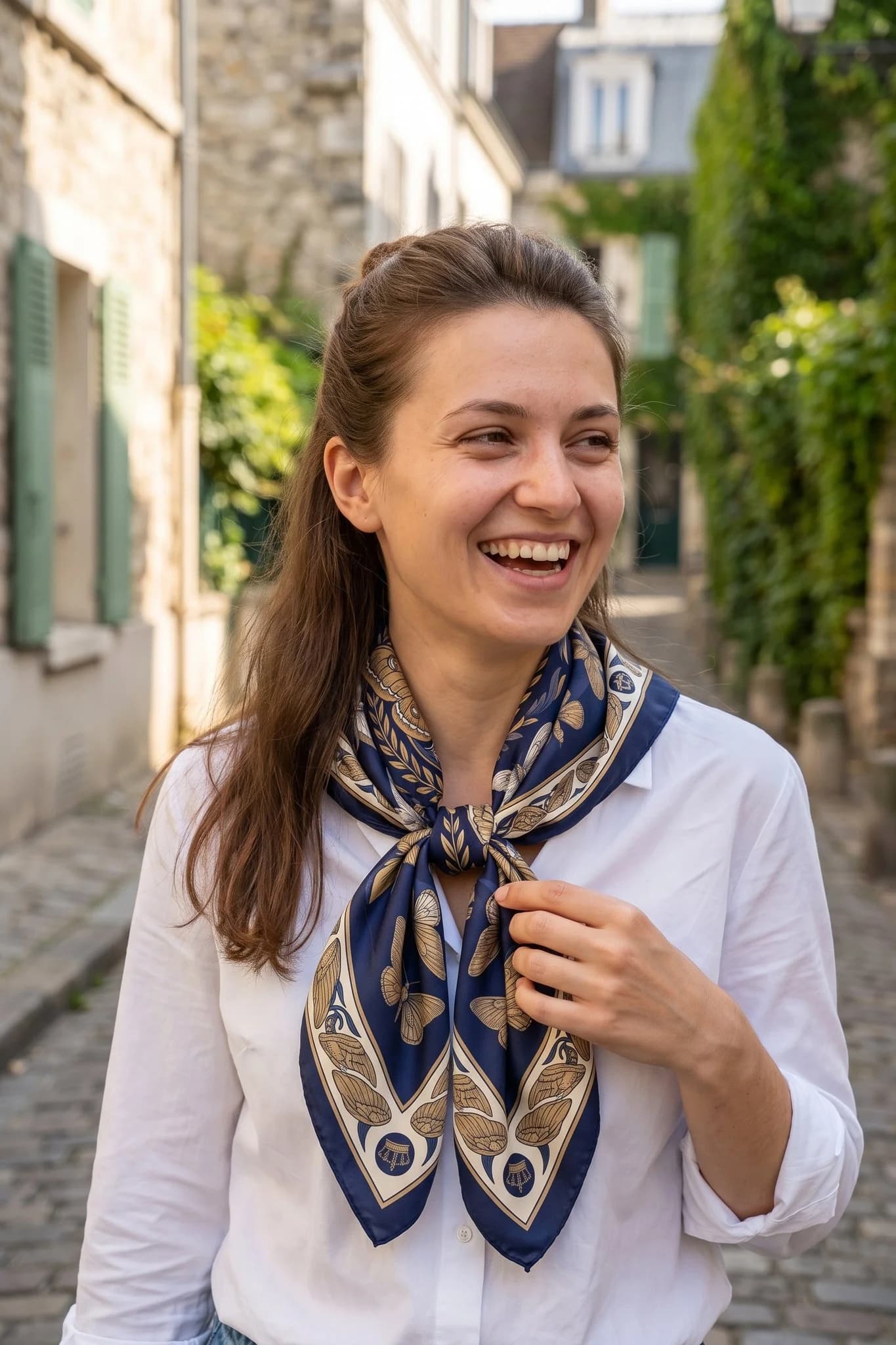 Frau trägt den Seidenschal Midnight Butterflies gebunden auf einer Straße in Paris