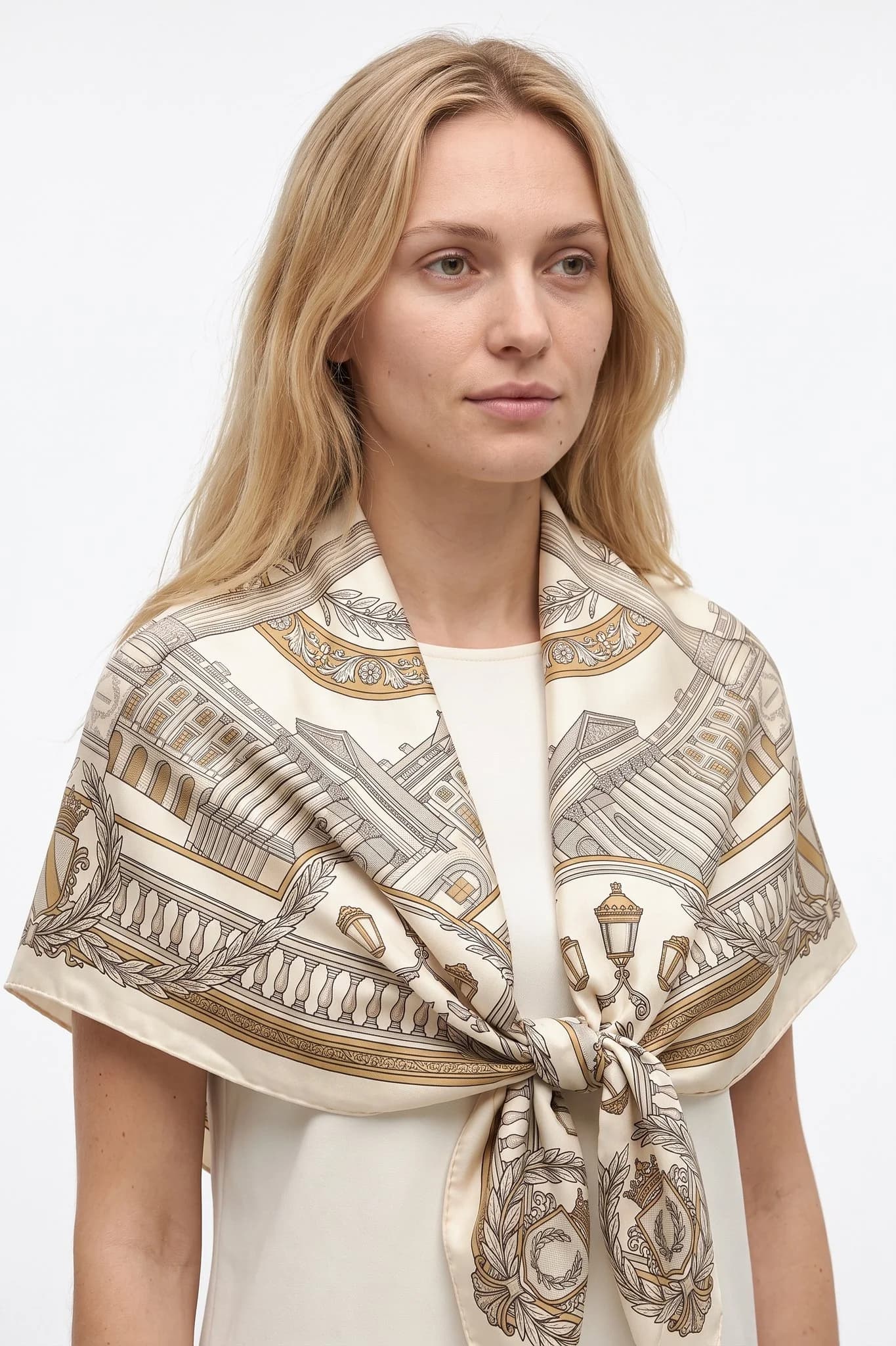 Foulard di seta 90 Place Vendôme indossato a triangolo sulle spalle di una donna, vista studio