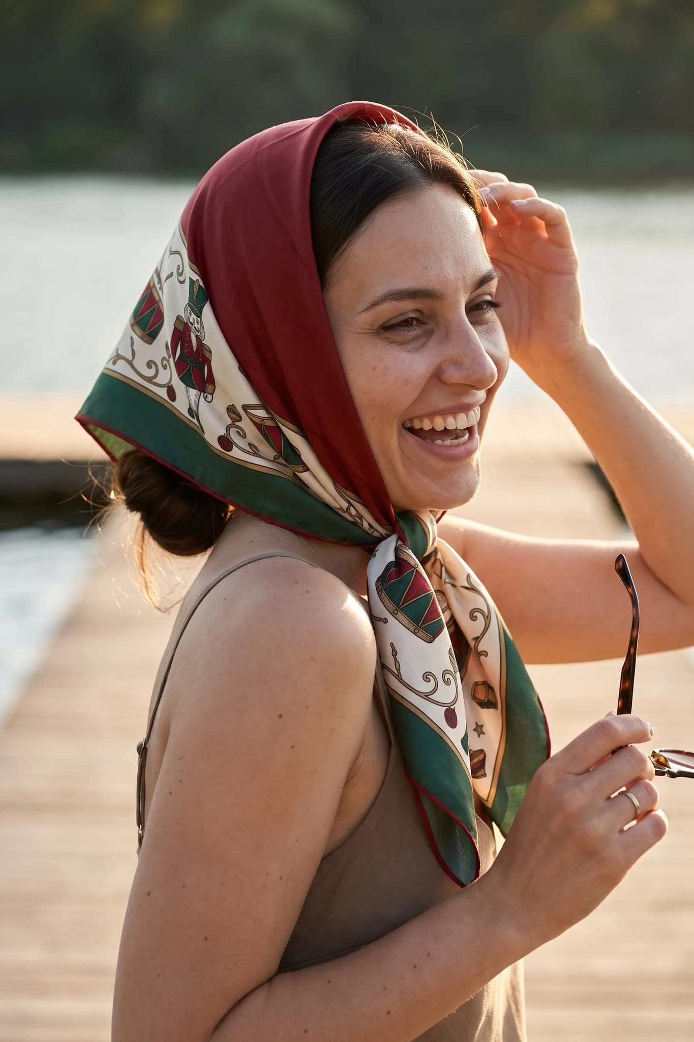 Woman wearing the Casse-noisette silk scarf as a bandana in her hair on a Paris street