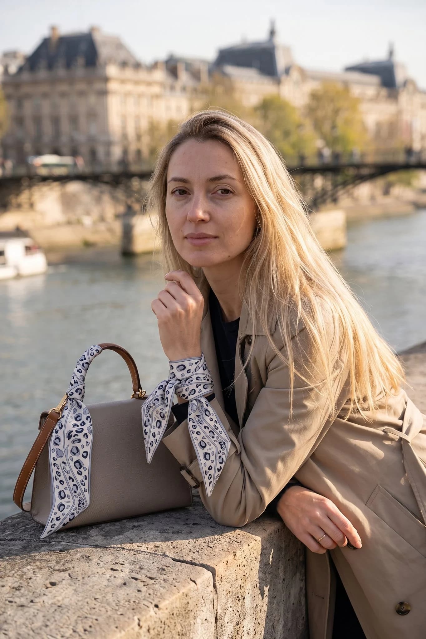 Woman wearing the snow leopard twilly on her wrist and on her bag handle, Parisian terrace