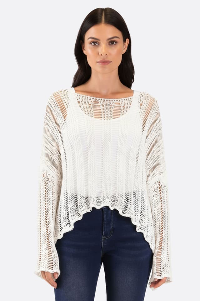 Maglia bianca in maglia traforata, chic e leggera, perfetta per outfit estivi eleganti, indossata con stile.