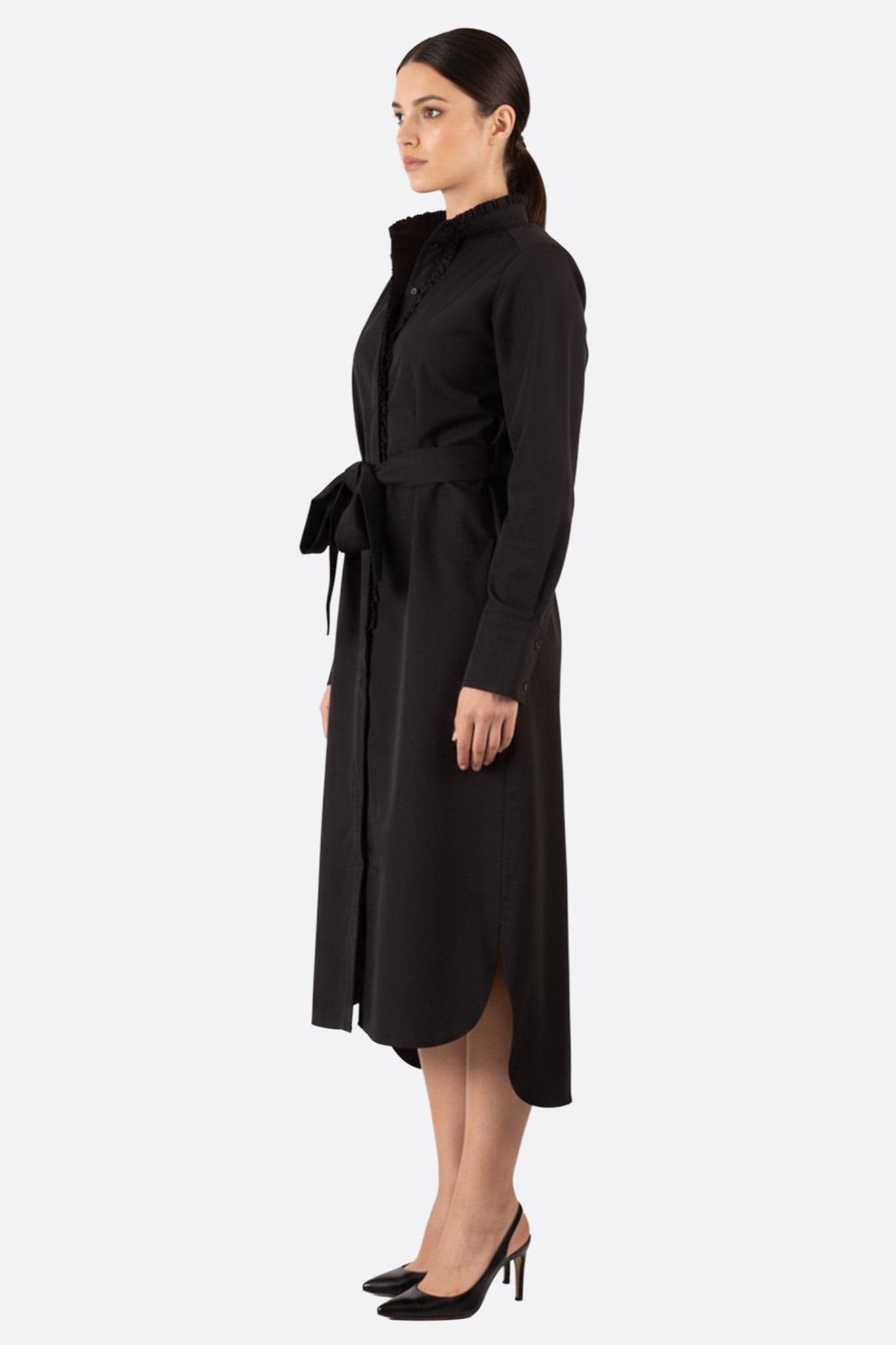 Dettaglio ravvicinato dell'abito camicia lungo nero con cintura, che mette in risalto il tessuto fluido e il taglio raffinato.
