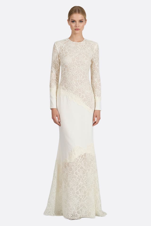 Abito lungo in pizzo avorio con maniche delicate, ideale per serate eleganti, mettendo in risalto una silhouette...