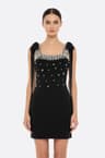 Short black dress adorned with pearls and shoulder bows