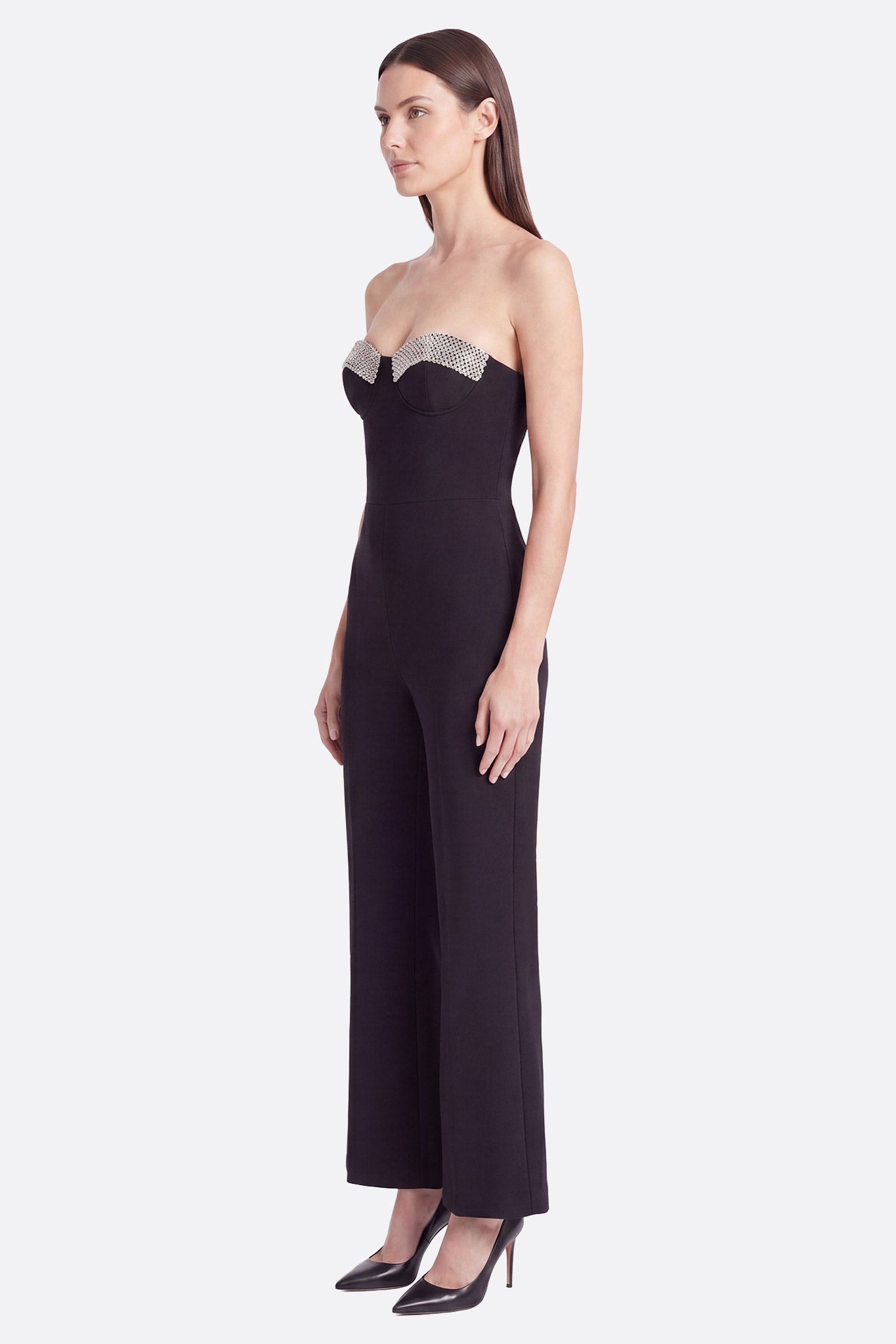 Combinaison bustier noire portée de profil avec détails argentés scintillants sur le décolleté