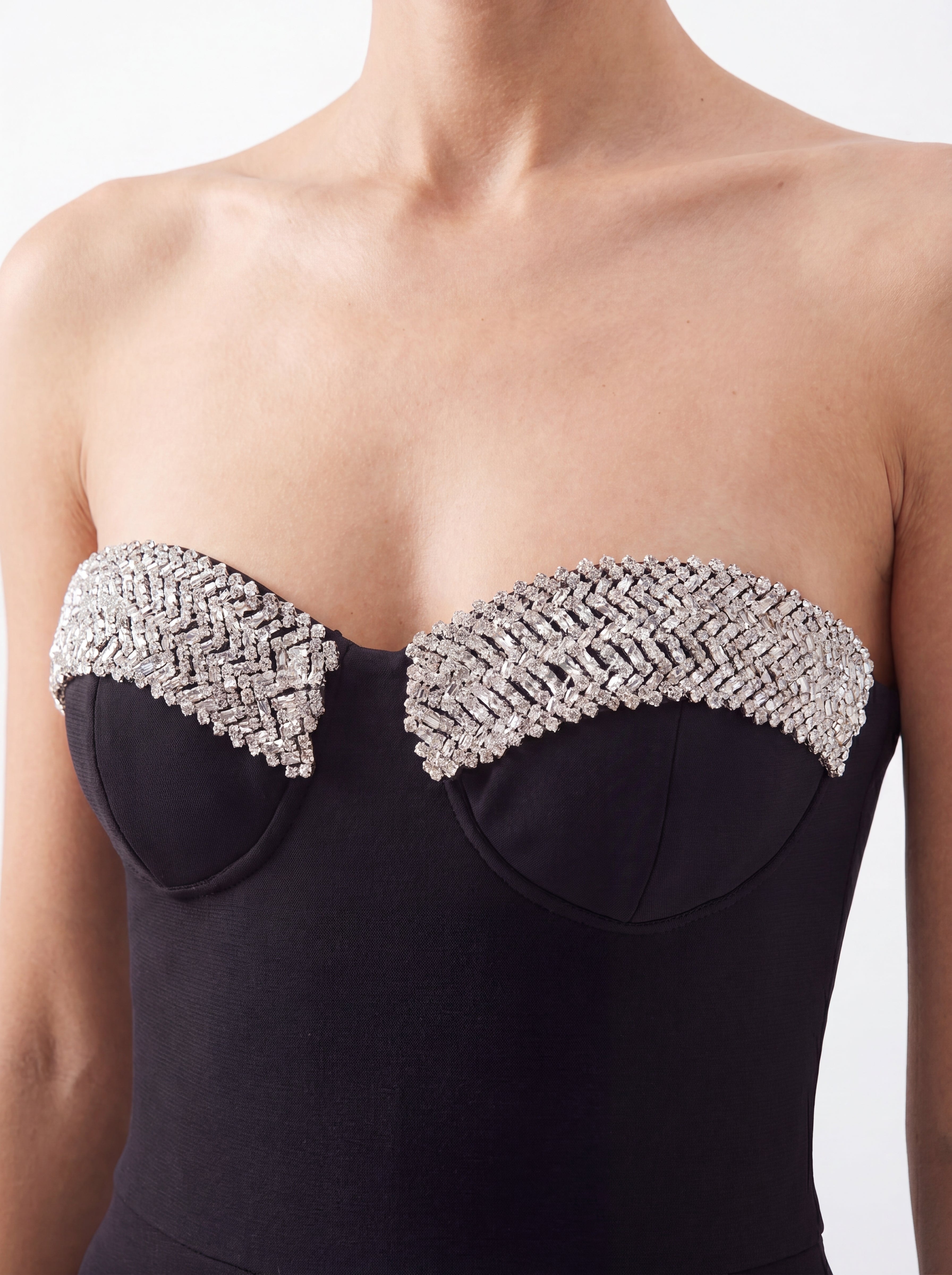 Combinaison bustier noire portée de face, zoom sur le corsage à bonnets et ses détails argentés