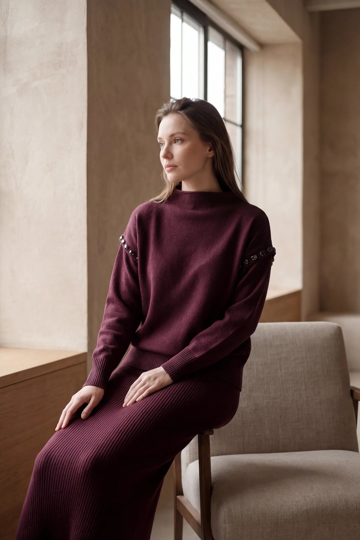Texture délicate de l'ensemble bordeaux en maille, jupe longue et pull col montant, idéal pour un brunch élégant.