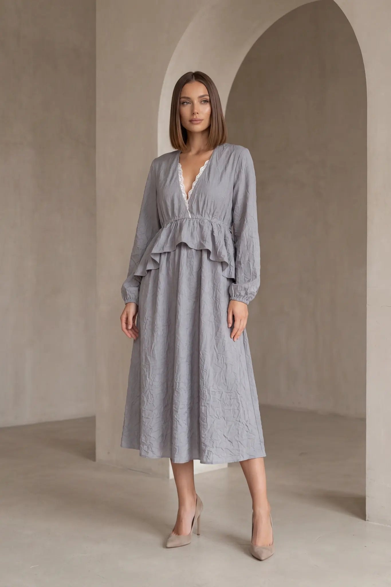 Graues plissiertes Midikleid mit V-Ausschnitt und verstellbarer Taille, vorne von einem Model getragen