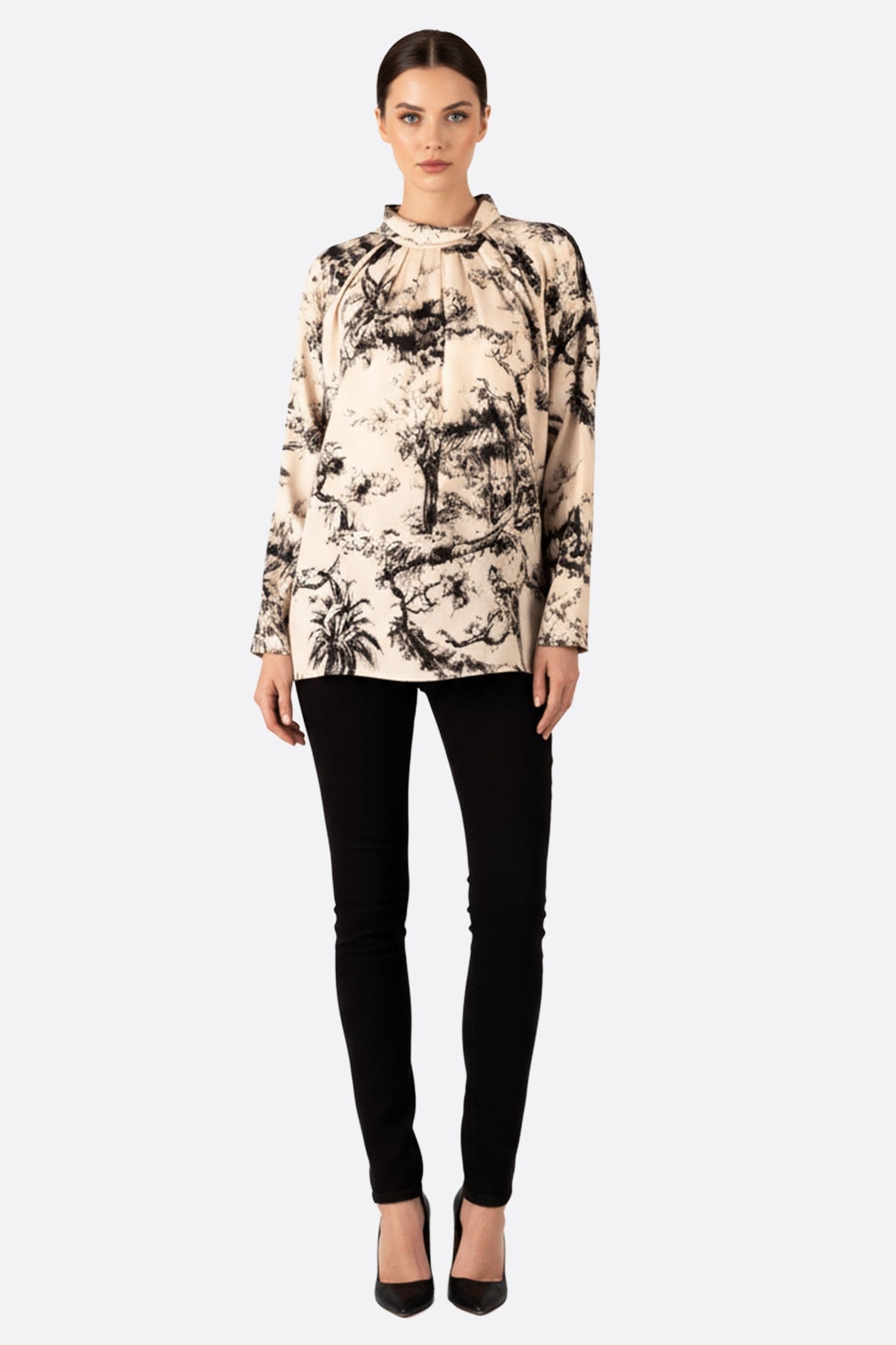 Close-up on the black and white toile de Jouy pattern of the oversize blouse, ideal for a chic evening or office look.