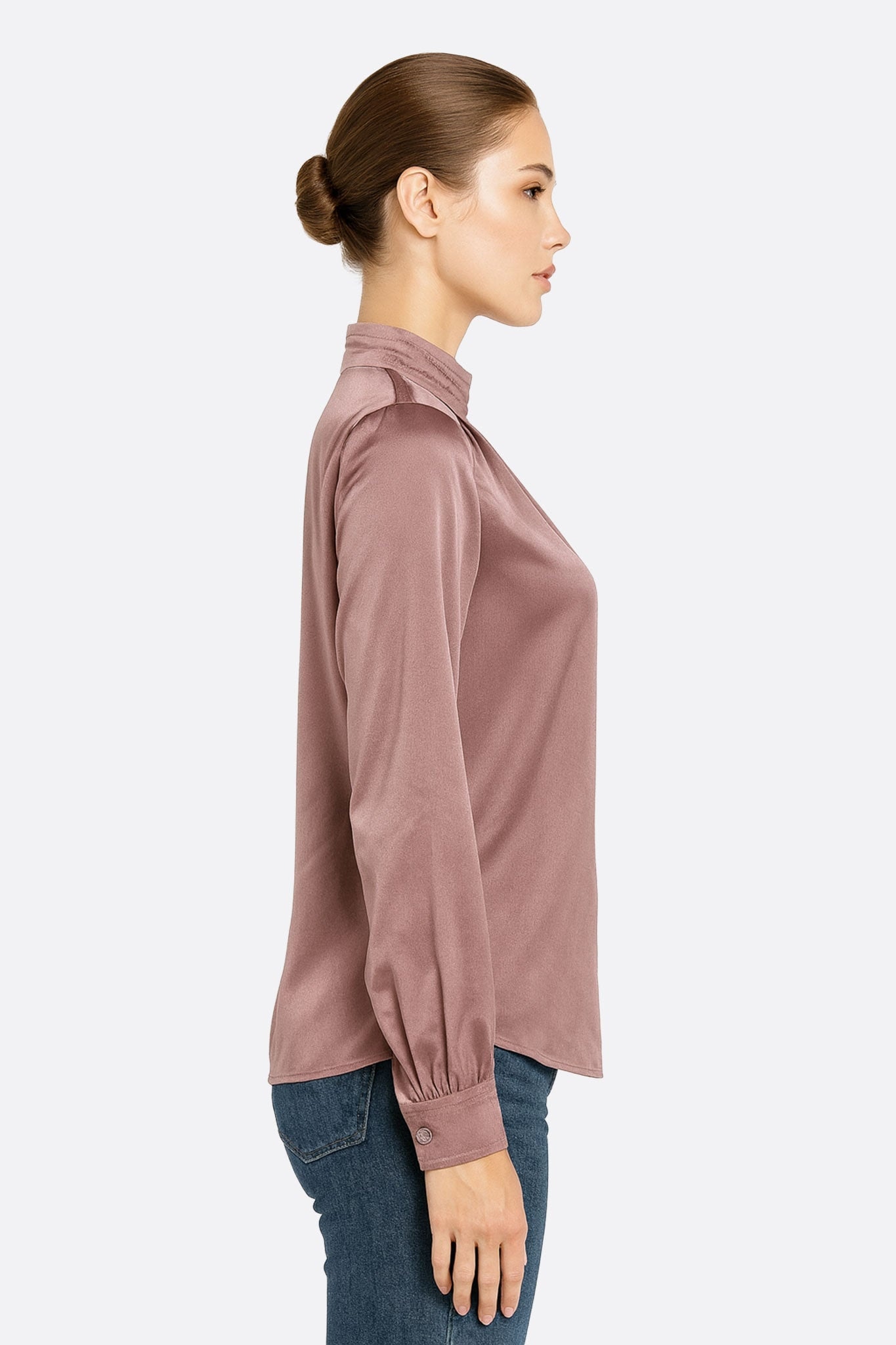Detail of the powder pink satin blouse, frilled collar, highlighting its soft and chic texture for a modern look.