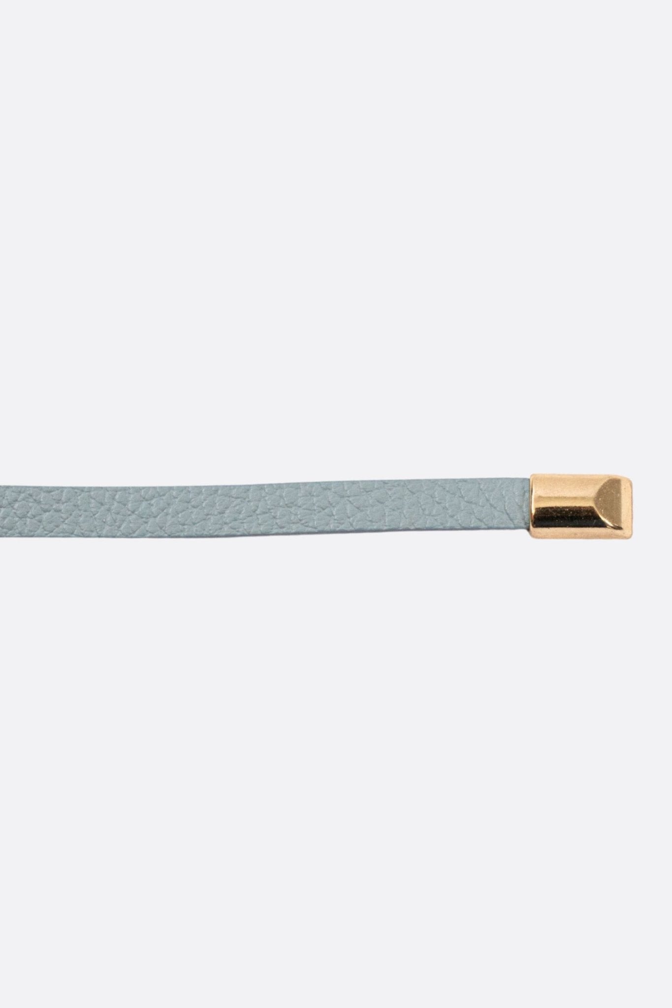 Detalles dorados en este cinturón fino de piel de ternera azul claro, ideal para un look chic y moderno.