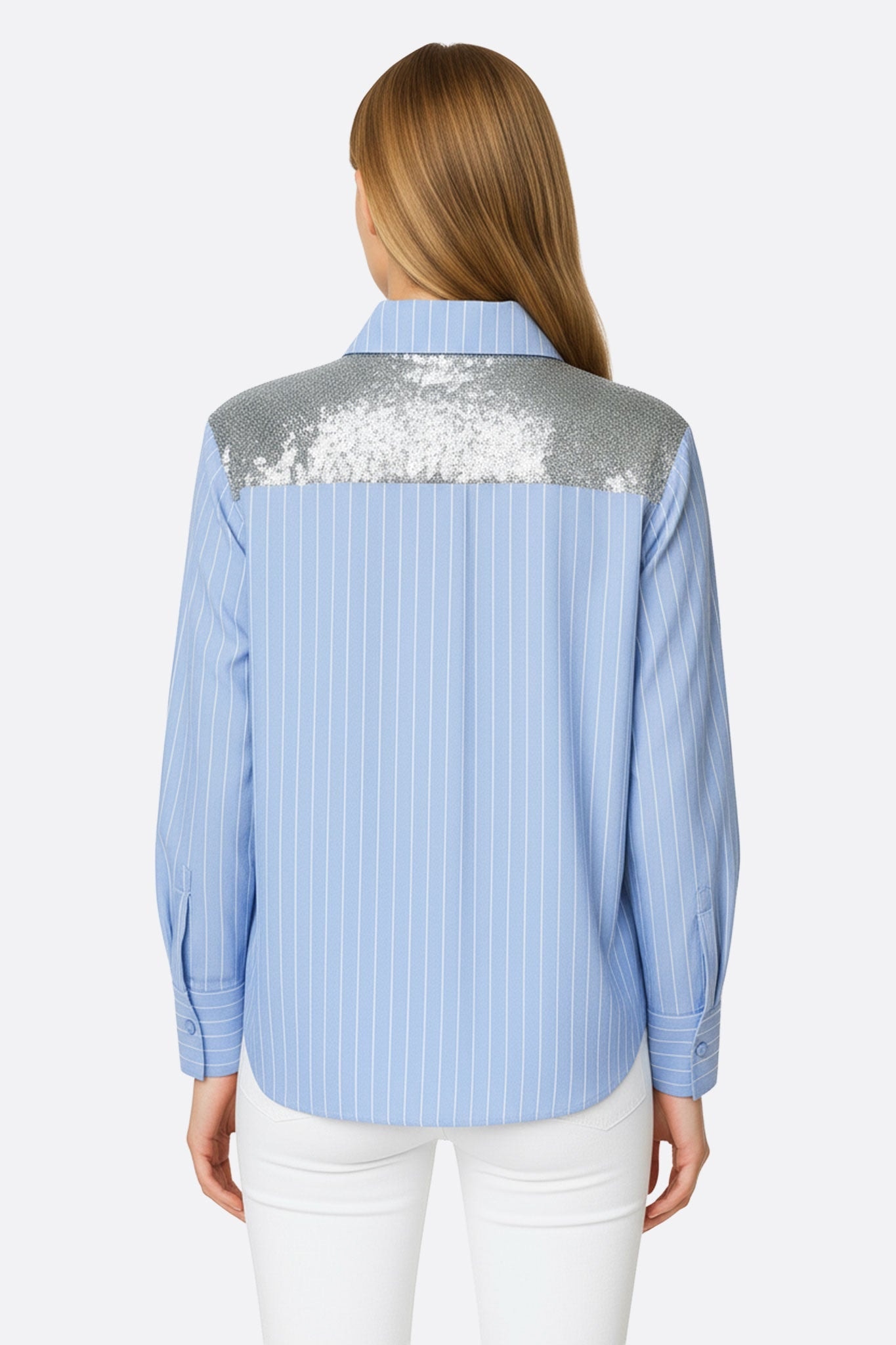 Primo piano sulle spalle paillettate di una camicia a righe azzurro cielo, che aggiunge un tocco glamour a un abbigliamento elegante da sera.