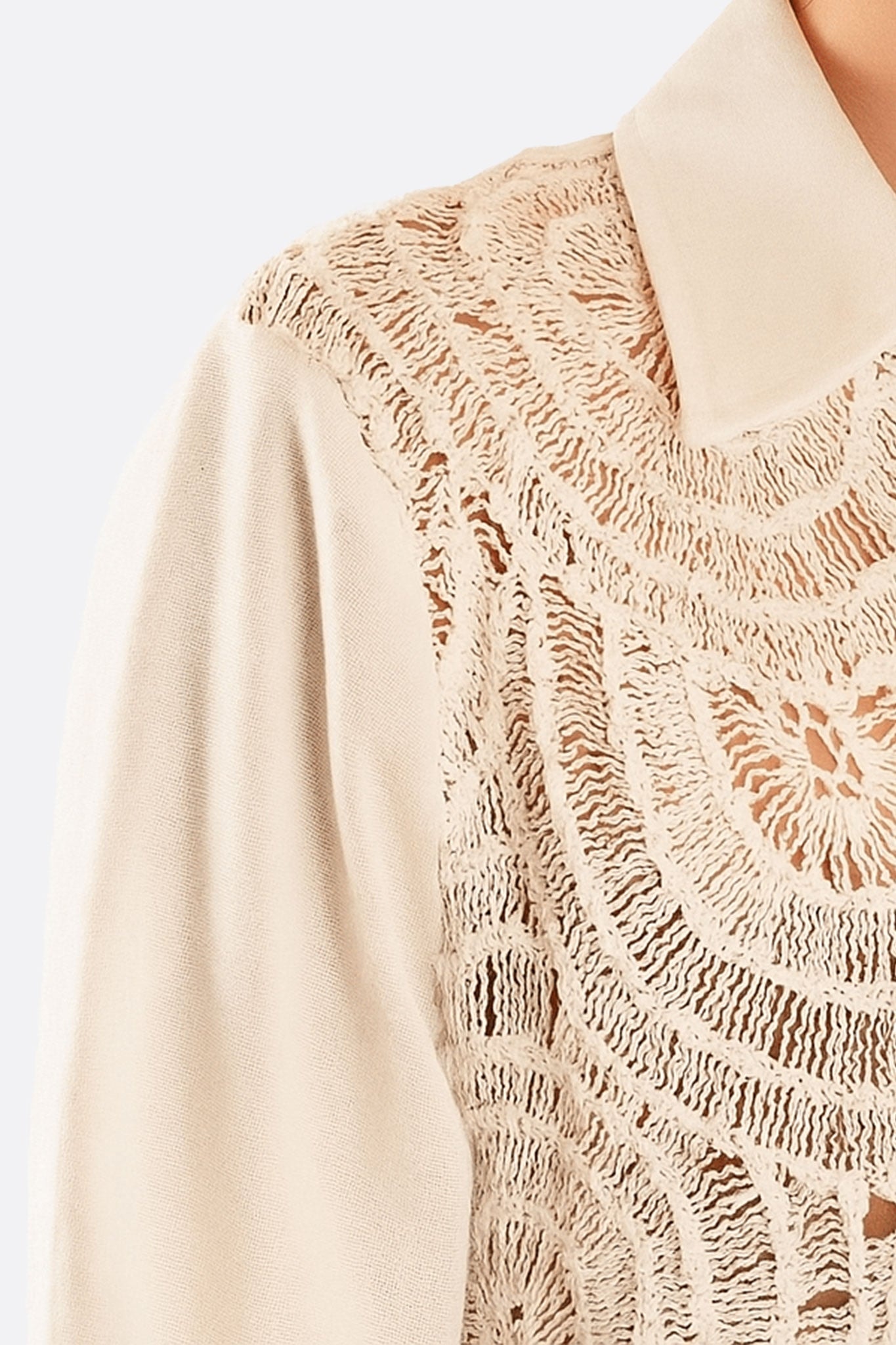 Détail de la chemise en coton blanc avec dentelle ajourée, un choix élégant pour un look décontracté et tendance.