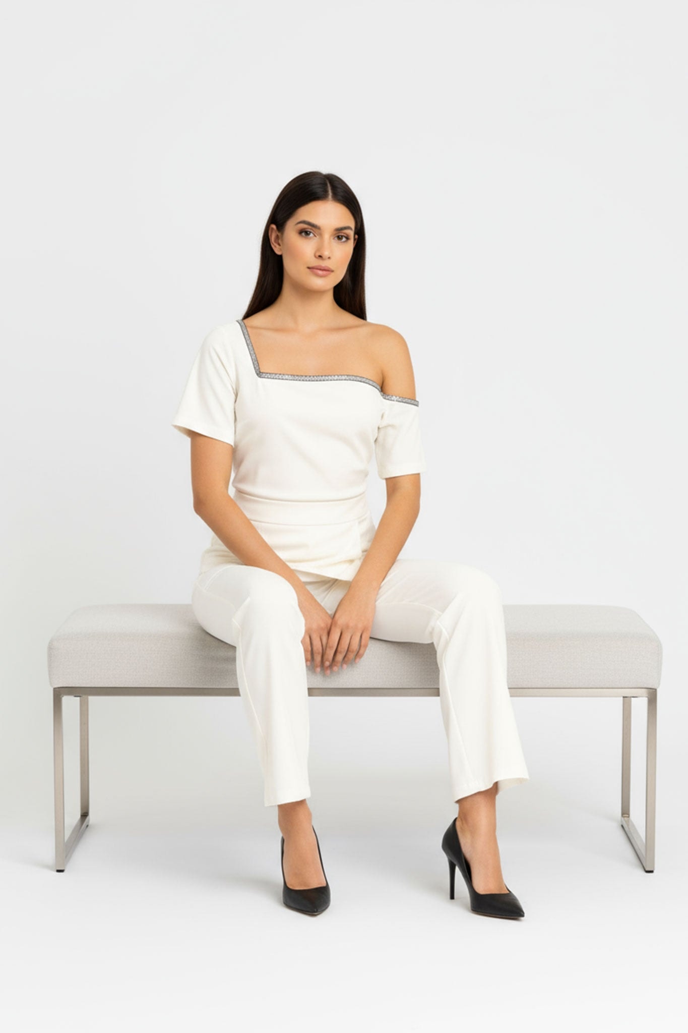 Profile of the white asymmetric jumpsuit from Misciano, accentuating the elegance of its modern cut and its detail