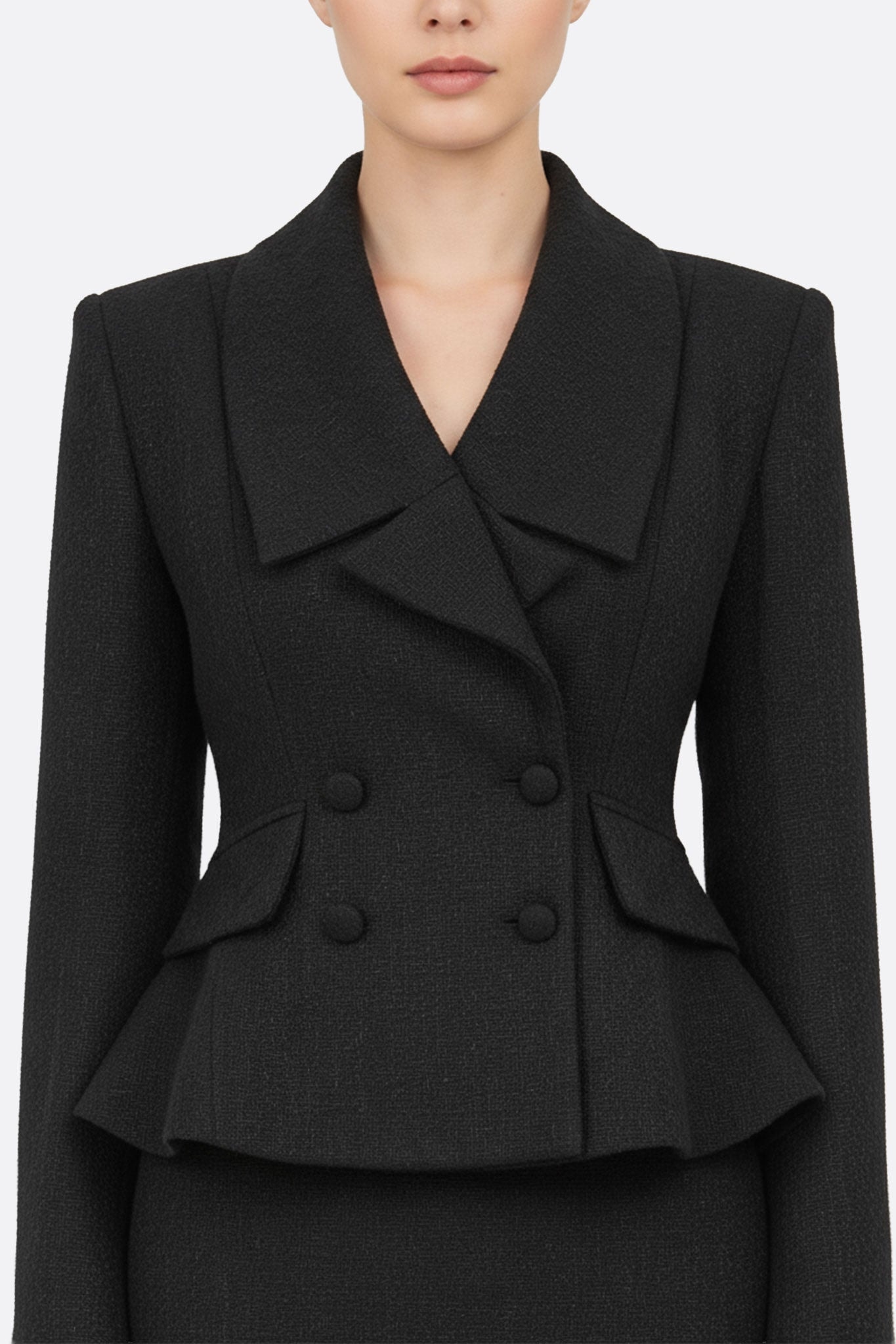 Primo piano sulla texture raffinata del tailleur con gonna nero, perfetto per una serata o una riunione in ufficio con eleganza.