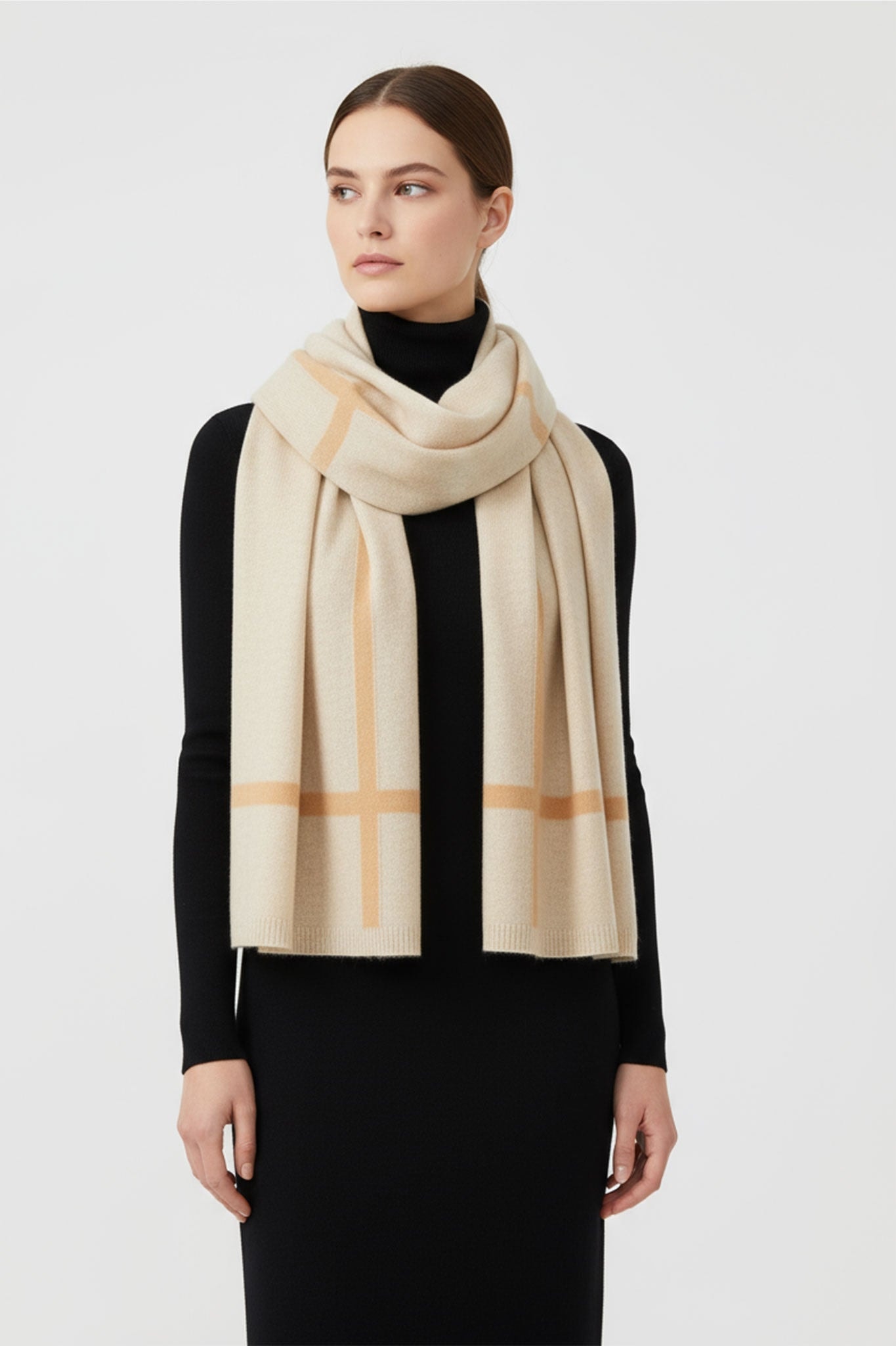 Elegant detail of a beige cashmere scarf with brown stripes, refined accessory to complete a winter outfit.